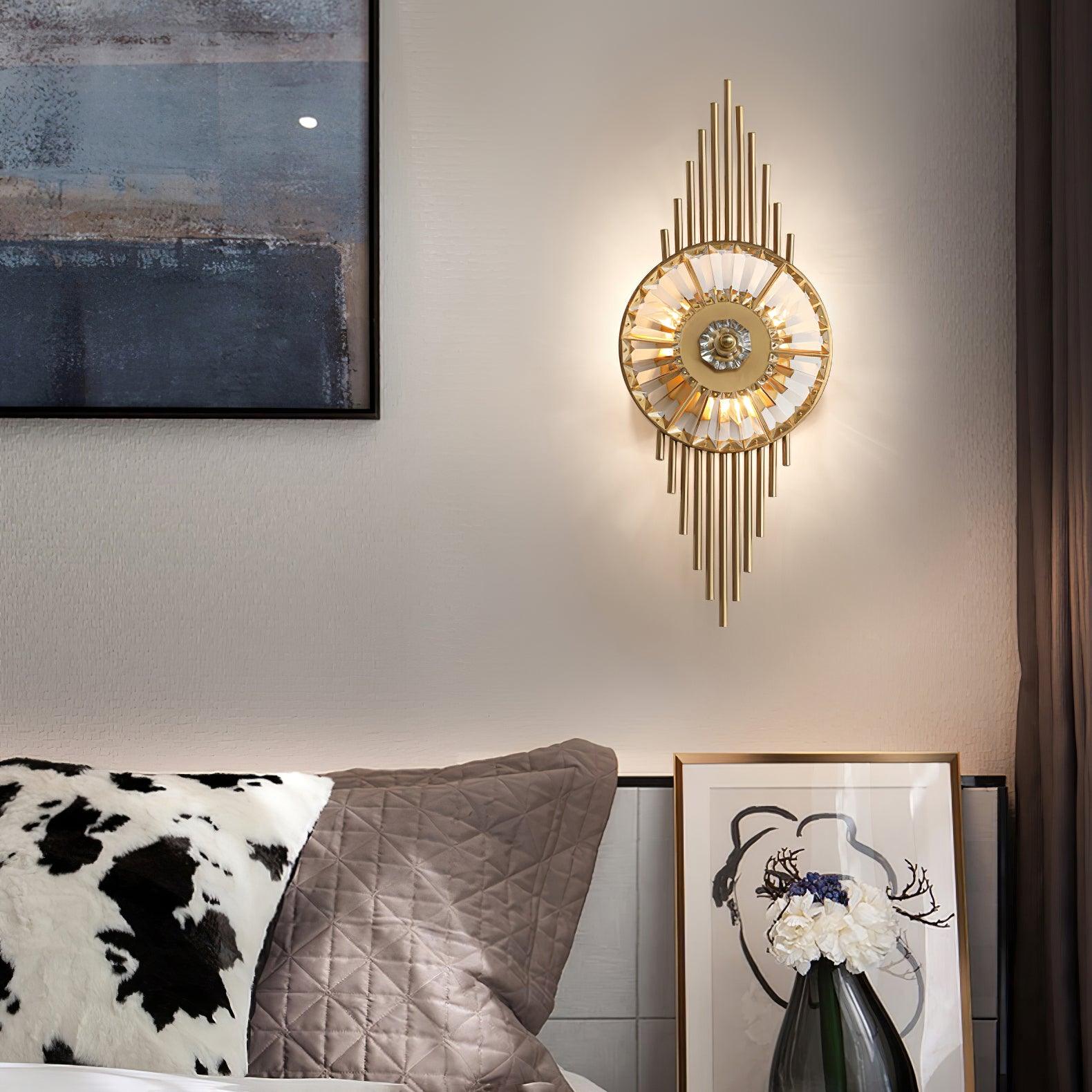 Illuminated Crystal Gear wall lamp above gray quilted cushions beside a black-framed abstract picture