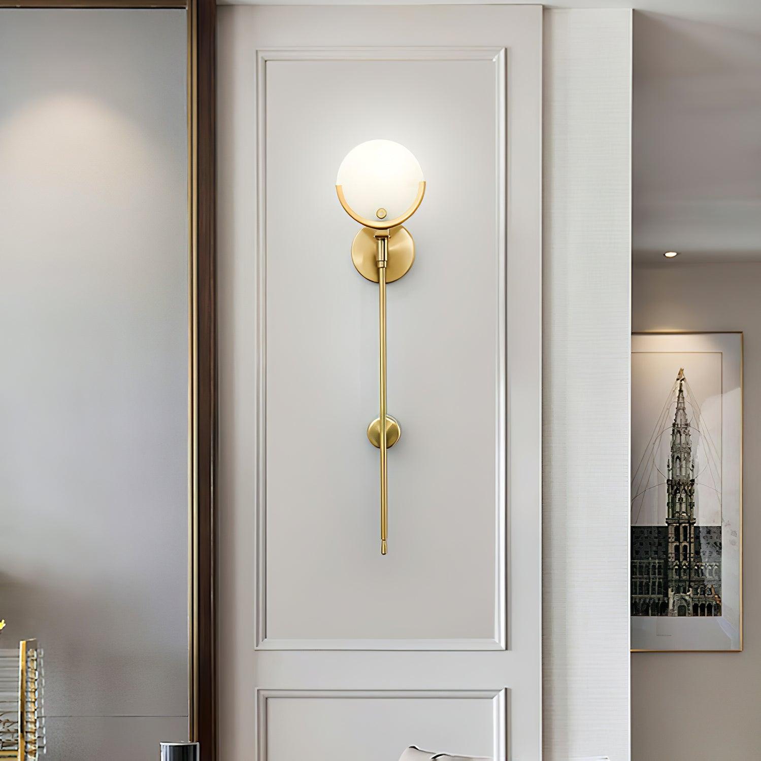 Front view of a long-stem Ava light centred in a white wall panel beside an interior opening and artwork