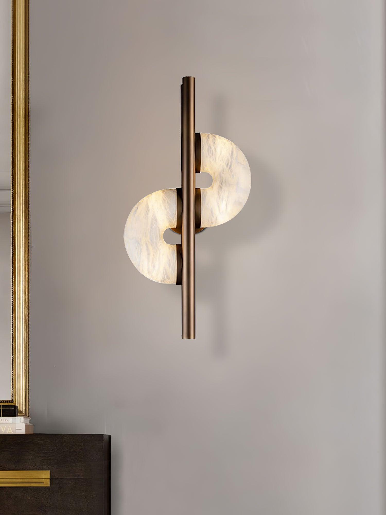 Glowing white stone discs beside a gold frame over a dark wooden dresser with gold handle