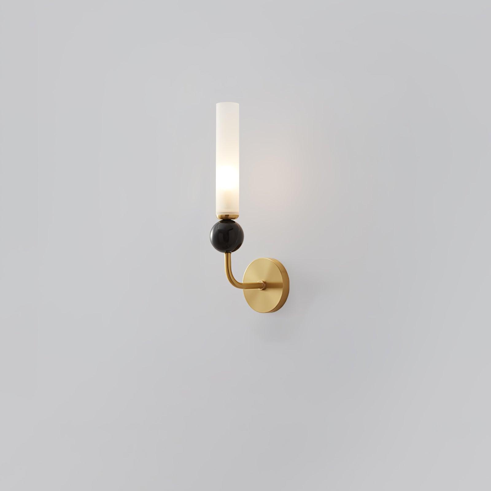 Curved-arm brass wall lamp with round plate, glossy dark marble sphere and lit upright white cylindrical diffuser