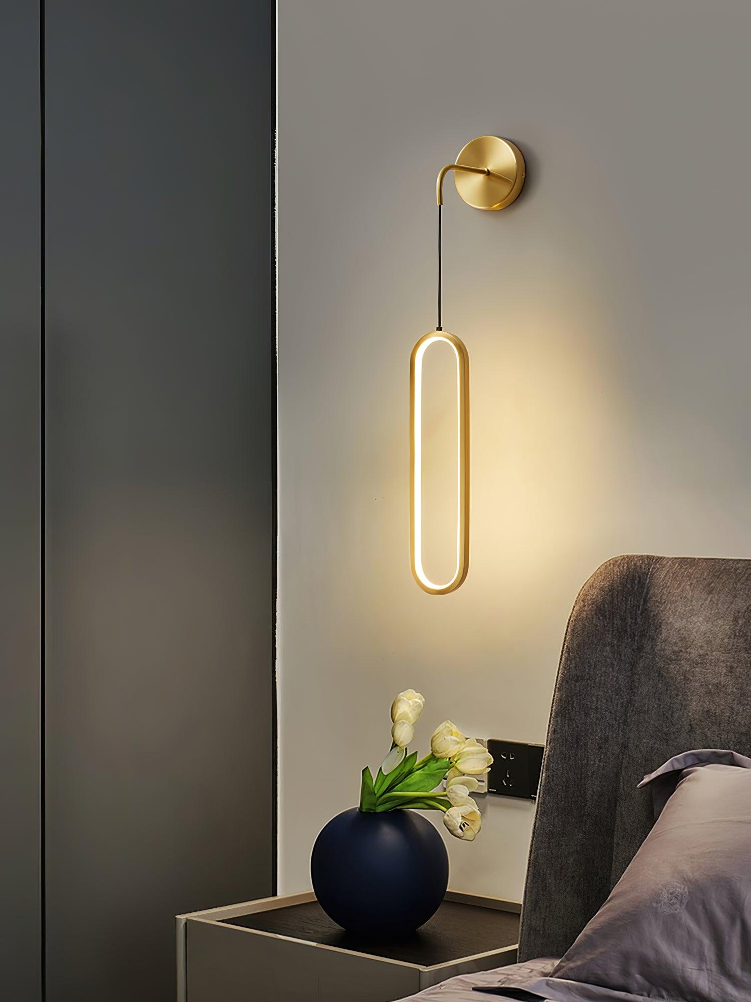 Illuminated oval ring beside an upholstered bed