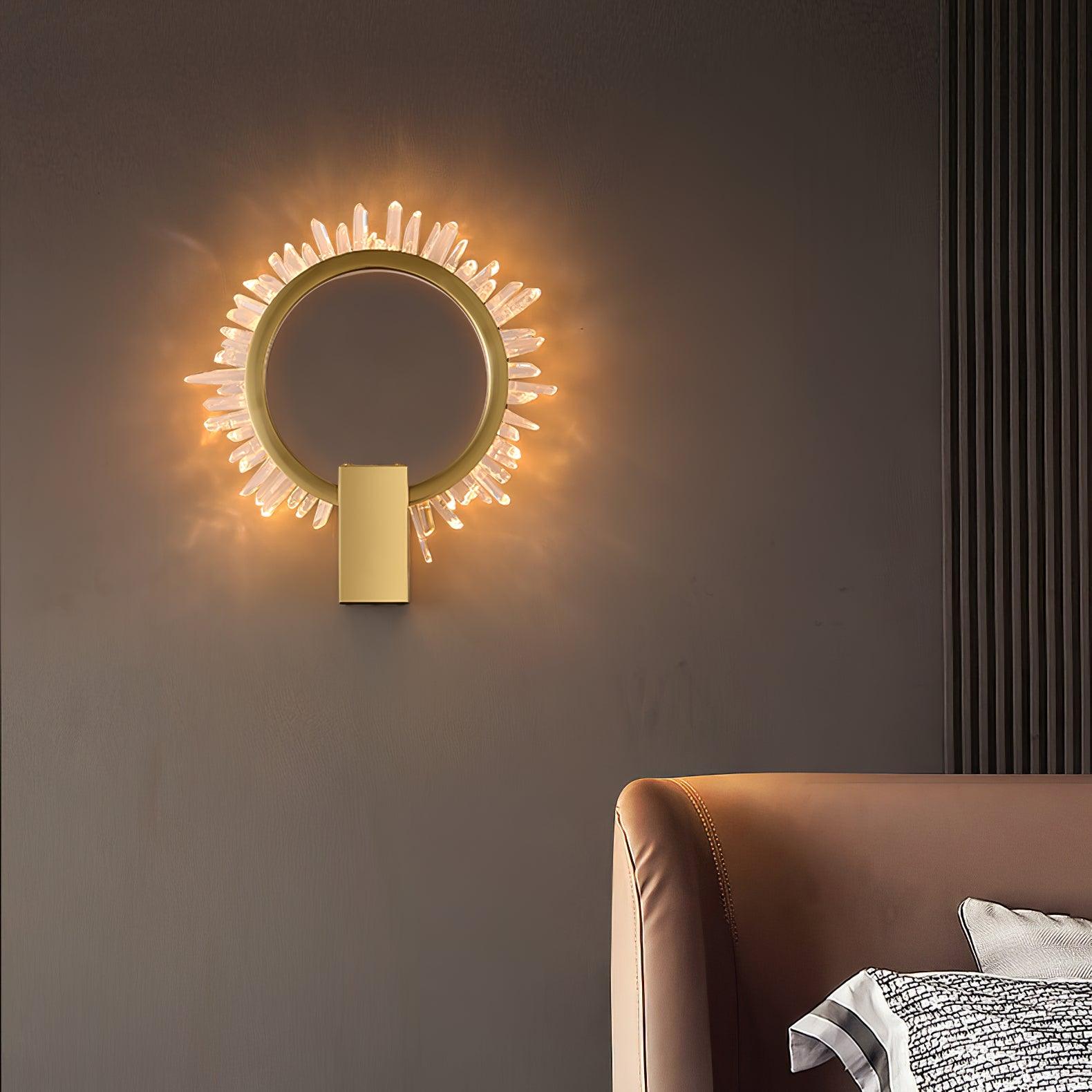 Gold crystal ring wall lamp above a tan headboard near a vertical slatted wall panel