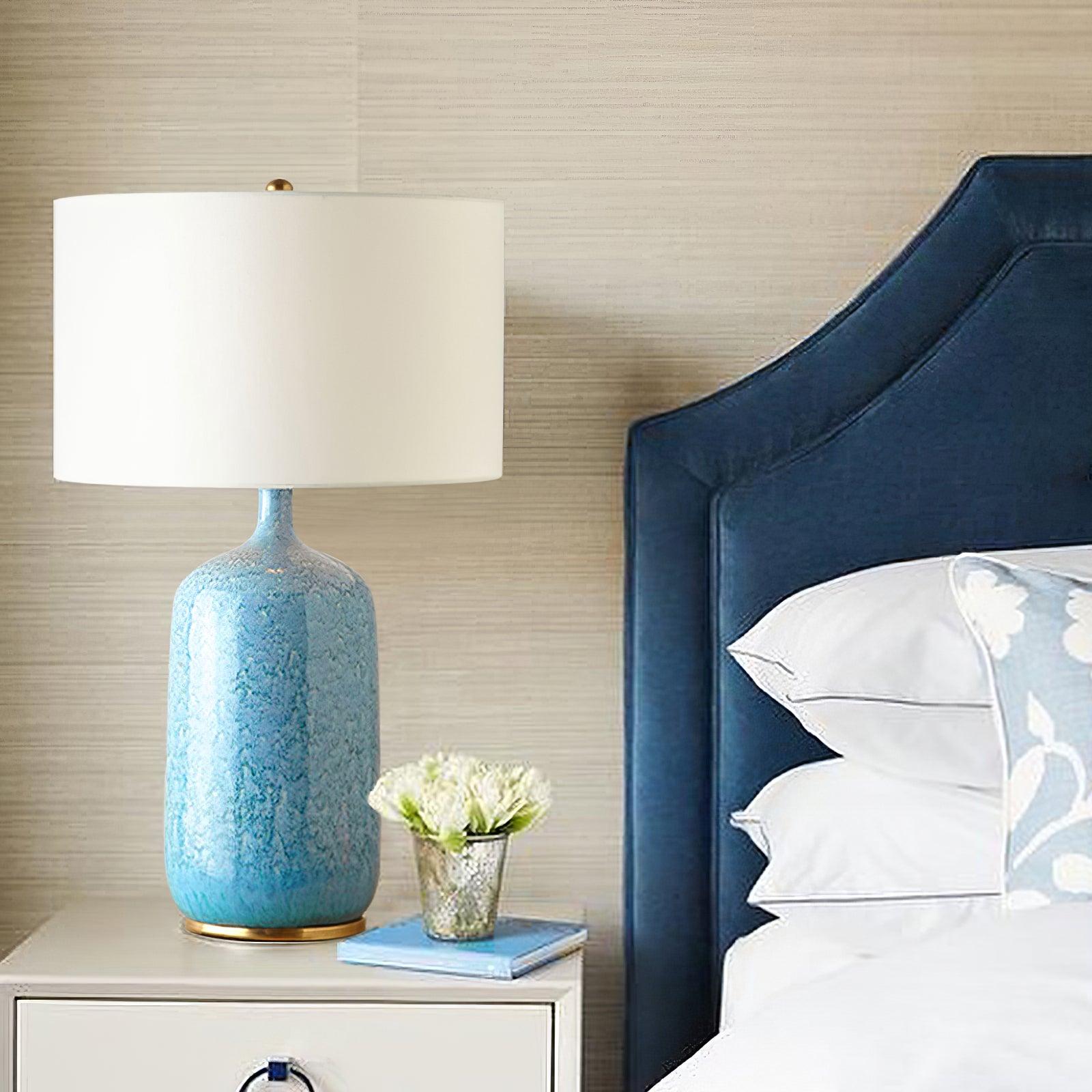 Culloden blue lamp beside a blue upholstered headboard