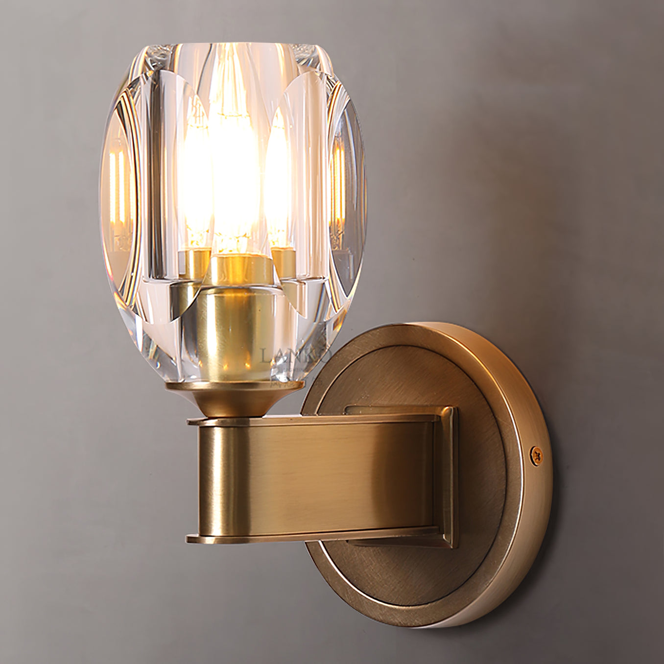 Angled view of lit crystal shade and round wall plate