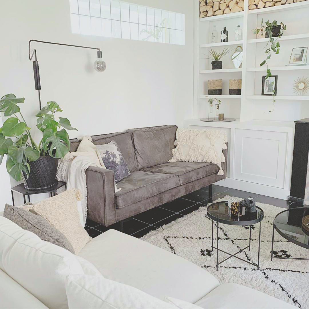 Swing wall light beside white living-room shelves