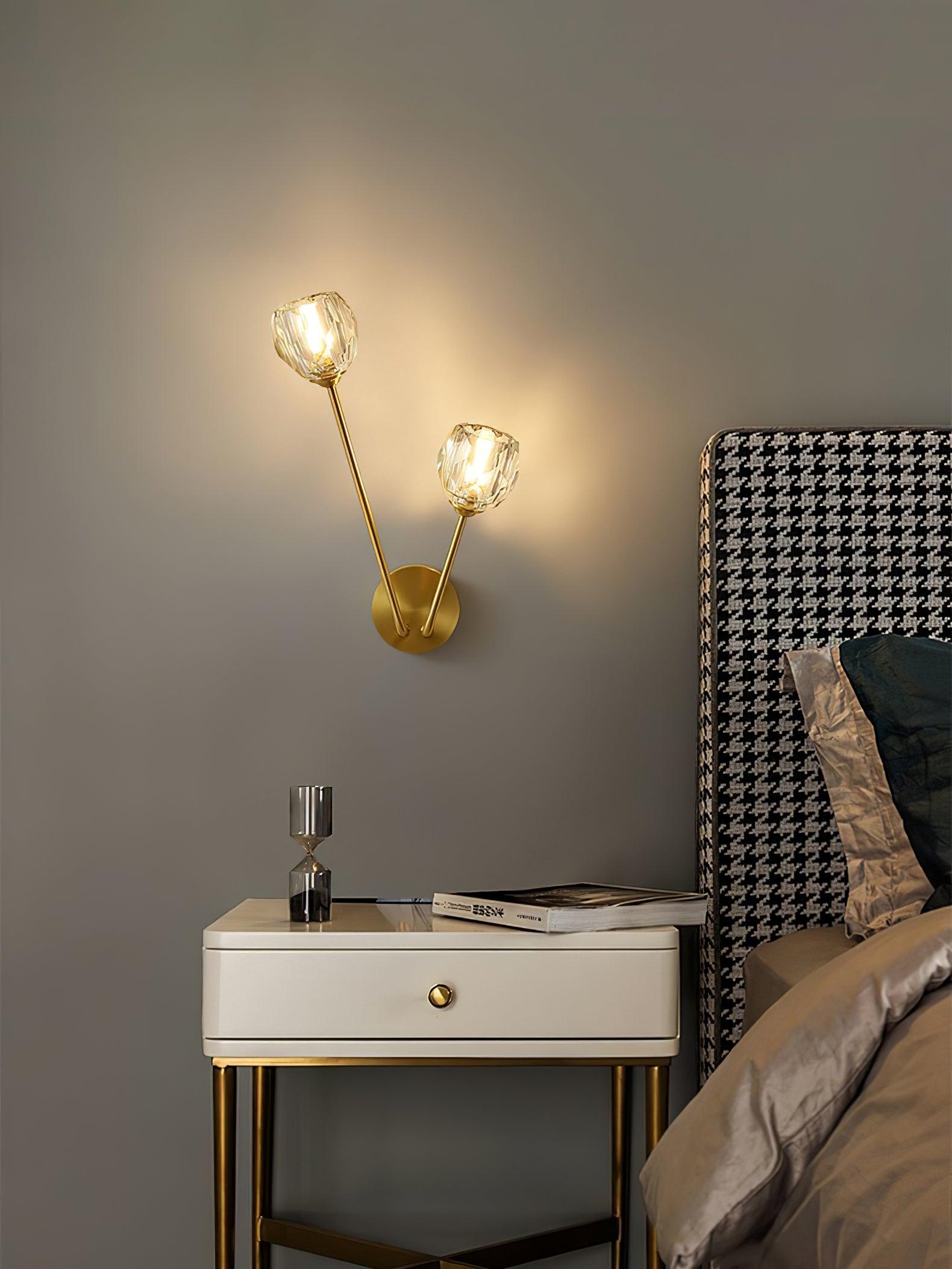 Wide bedside view of lit faceted glass shades beside a houndstooth headboard and white cabinet