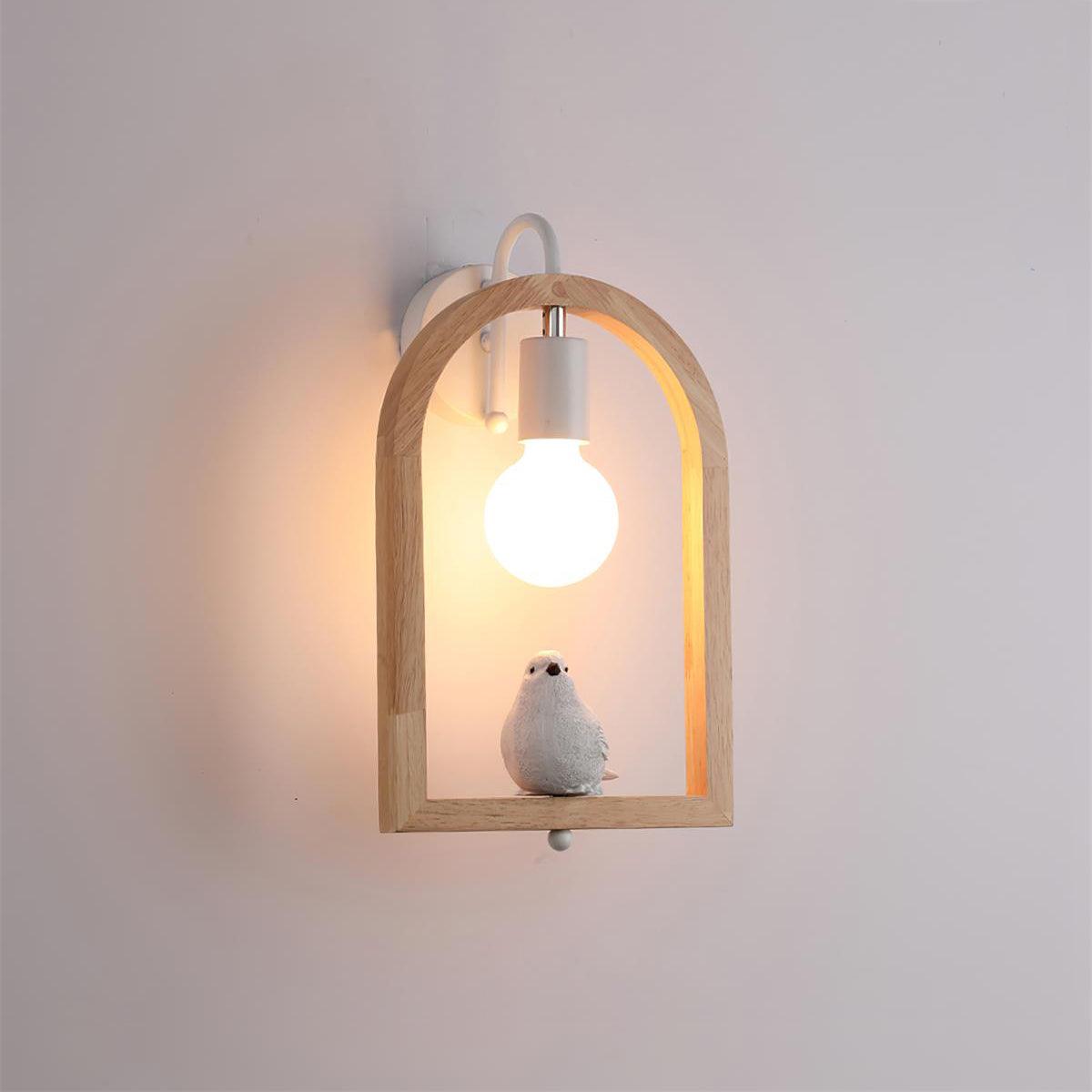 Model A bird wall lamp against a pale wall, with a glowing globe bulb, wooden arch and white curved wall bracket