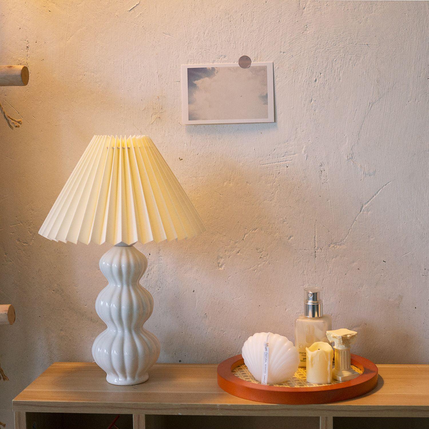 Leo lamp on a cabinet beside candles and a wall print