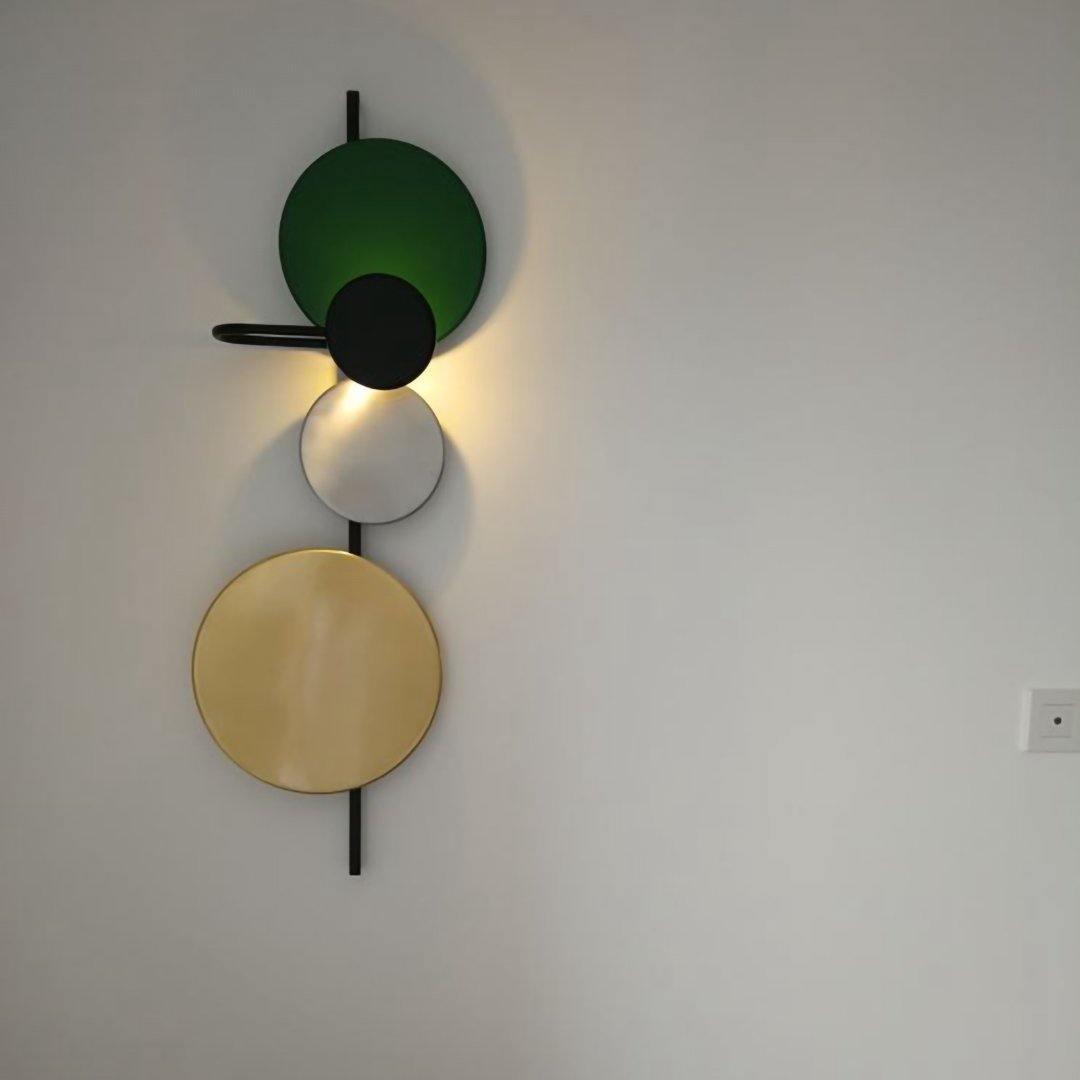 Green disc wall light above a chair