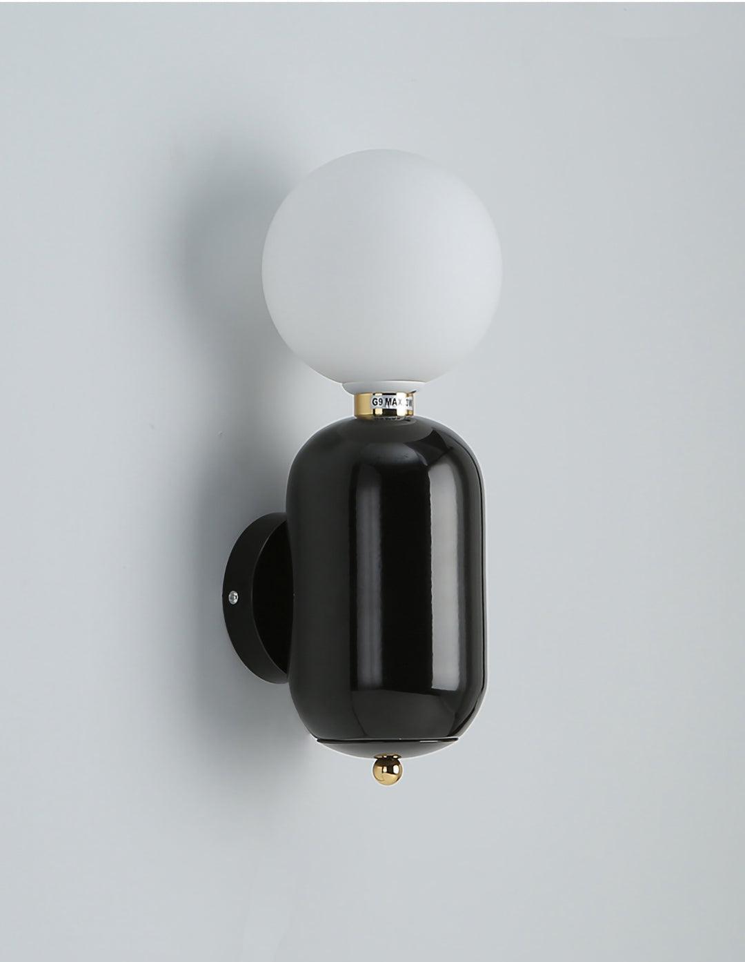 Black rounded wall light with unlit-looking white globe, black circular plate and small gold-tone lower finial