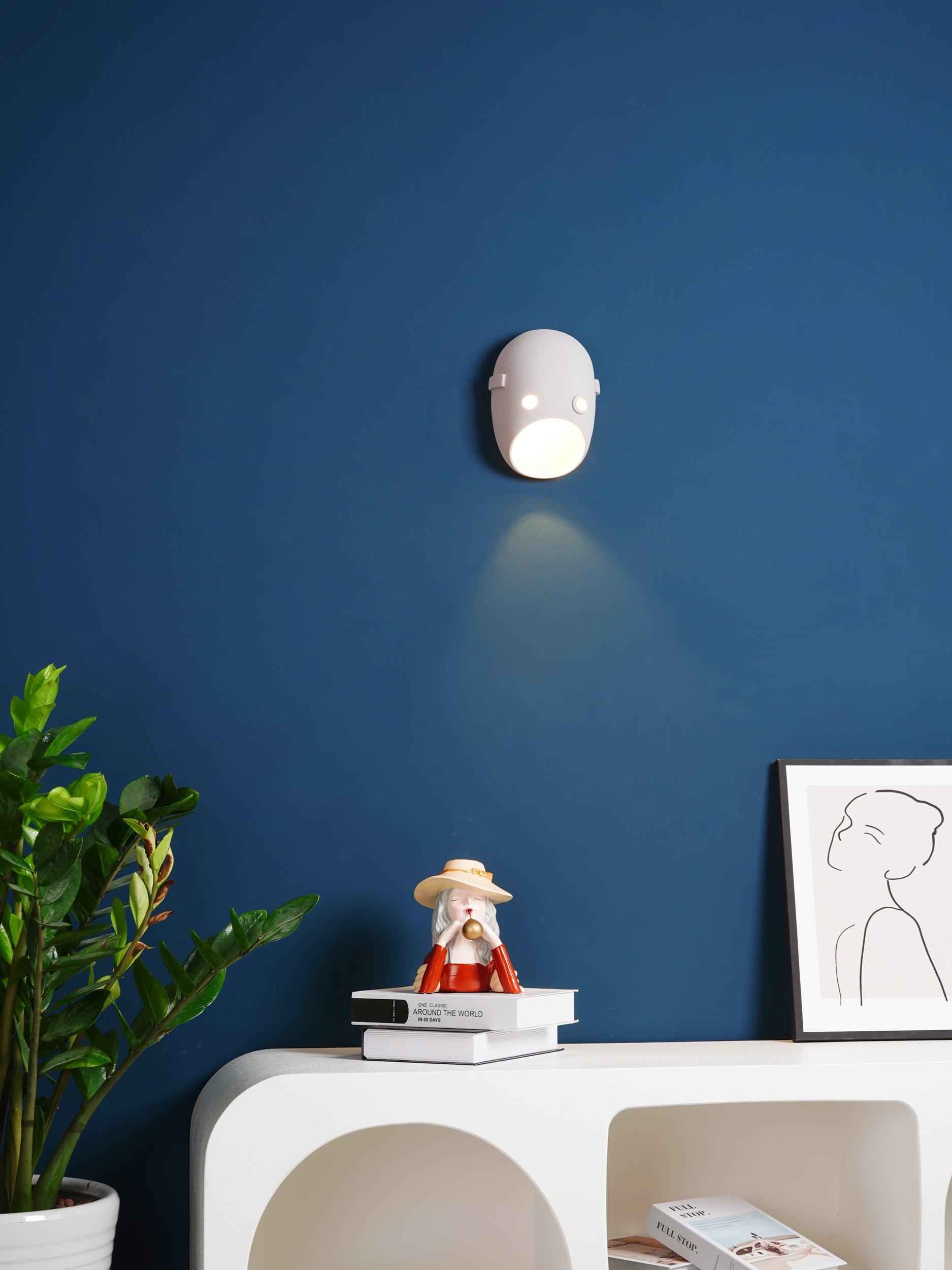 Illuminated face light above a console on a blue wall