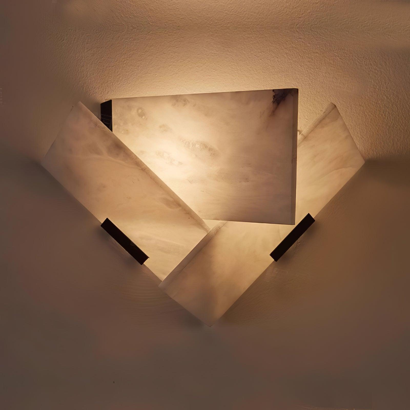 Close lit overlapping white stone panels and black supports casting light on a textured wall