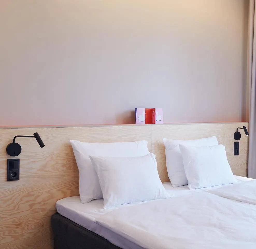 Pair of black reading lights beside a bed