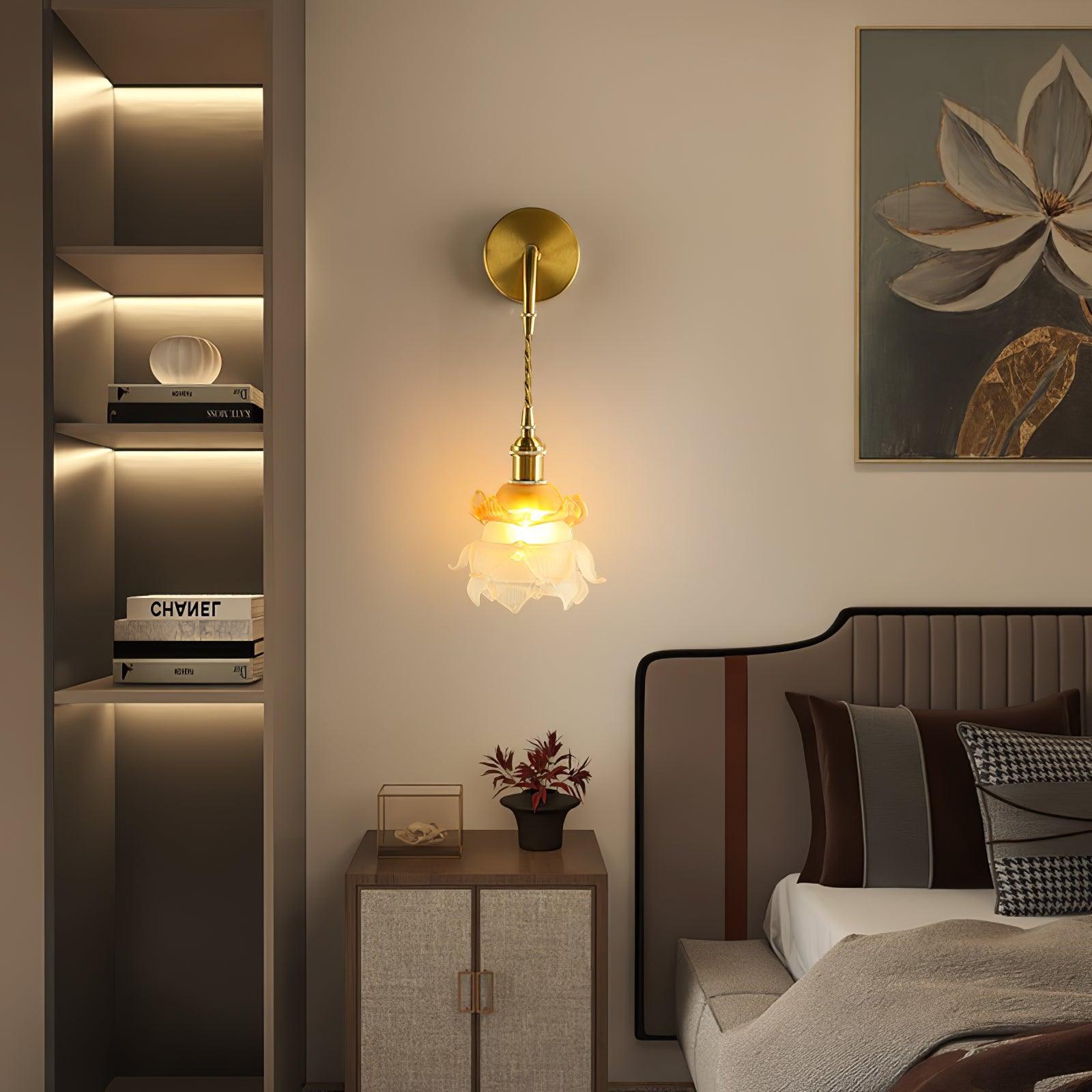 Brass and floral glass Laura wall light above a bedside table