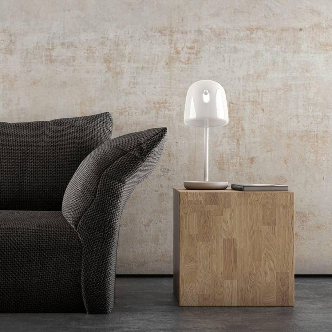 White Mona lamp on a wooden side table near a sofa