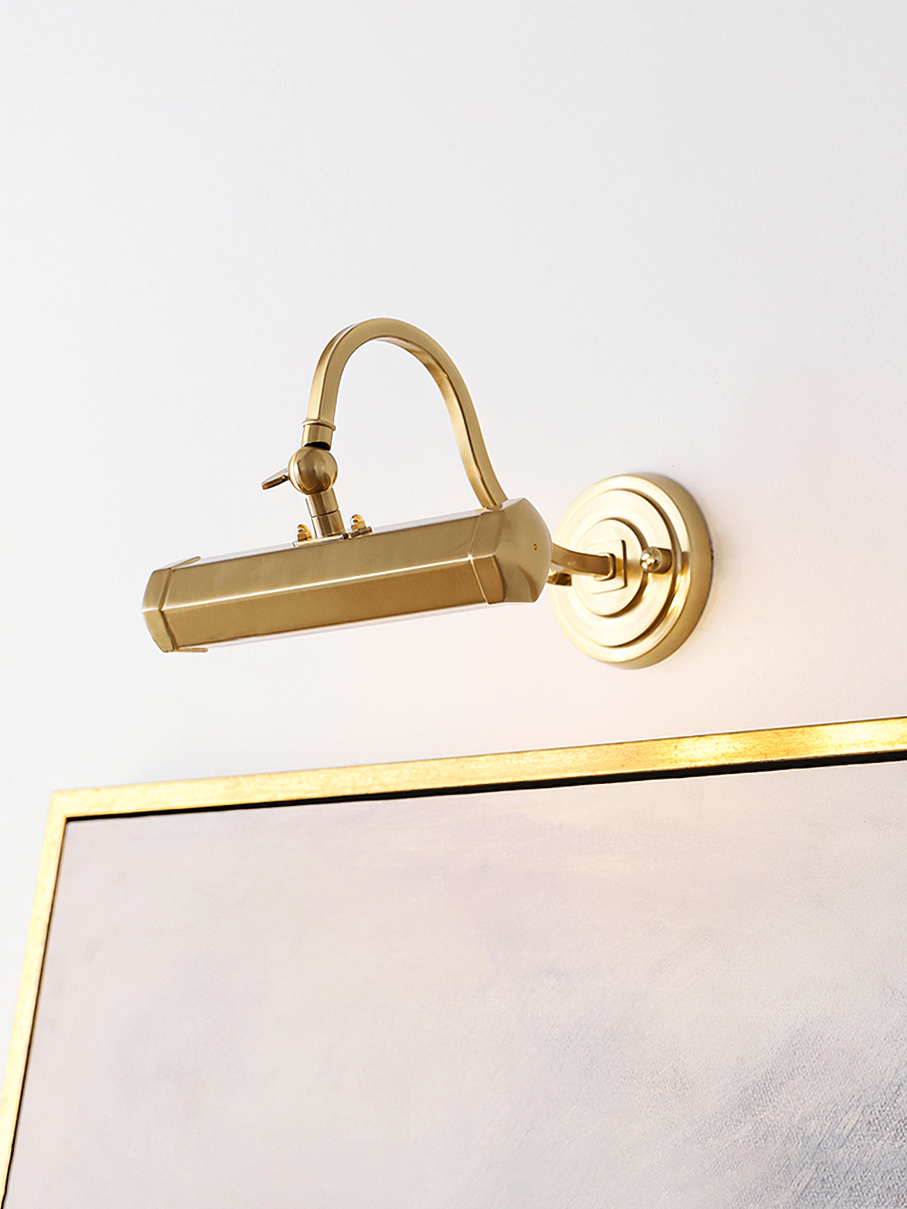 Curved-arm Gold picture light above a frame