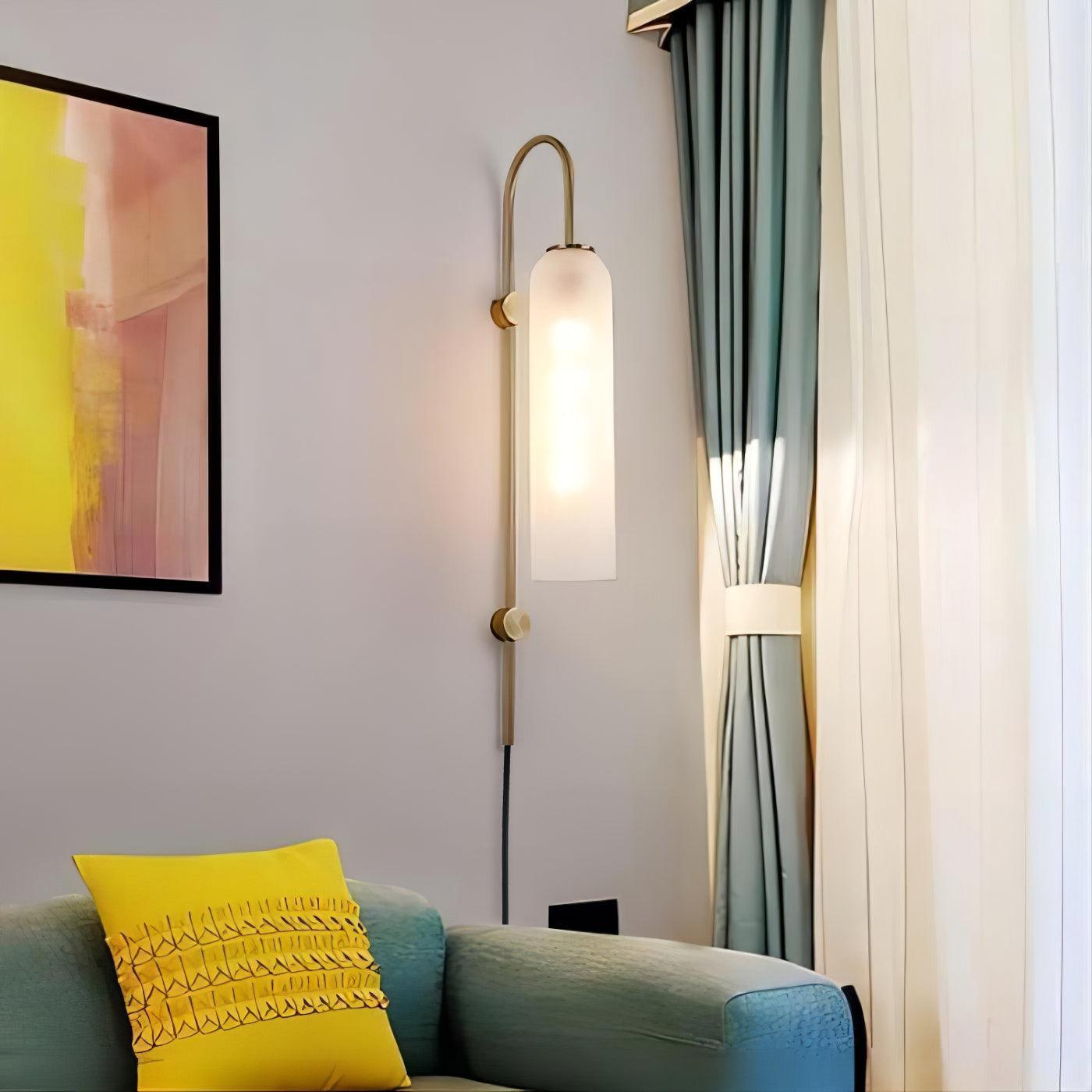 White cylindrical lamp beside a sofa and curtains