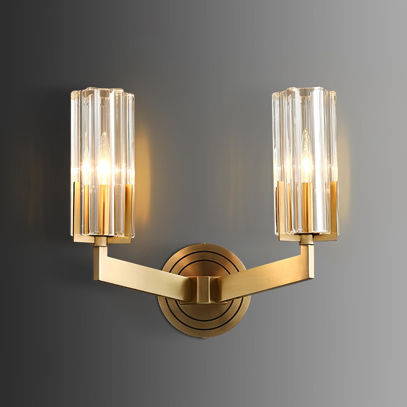 Wide Kayla option with two lit clear fluted shades on symmetrical brass arms from one ringed round wall plate