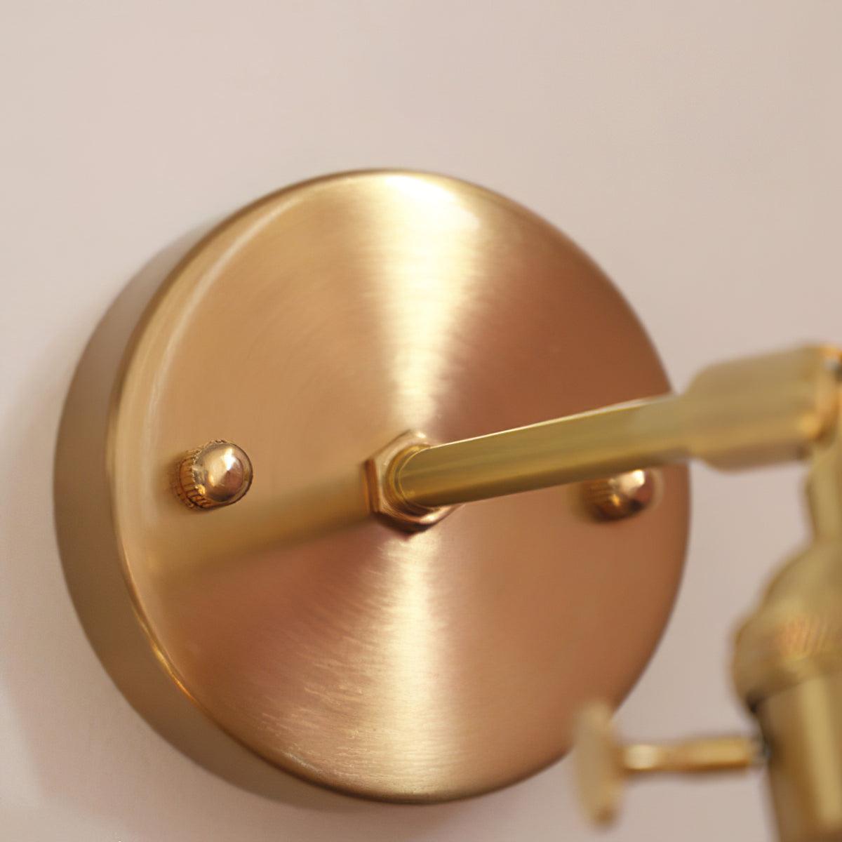 Close detail of the gold-tone round wall plate, two front fasteners and short horizontal arm