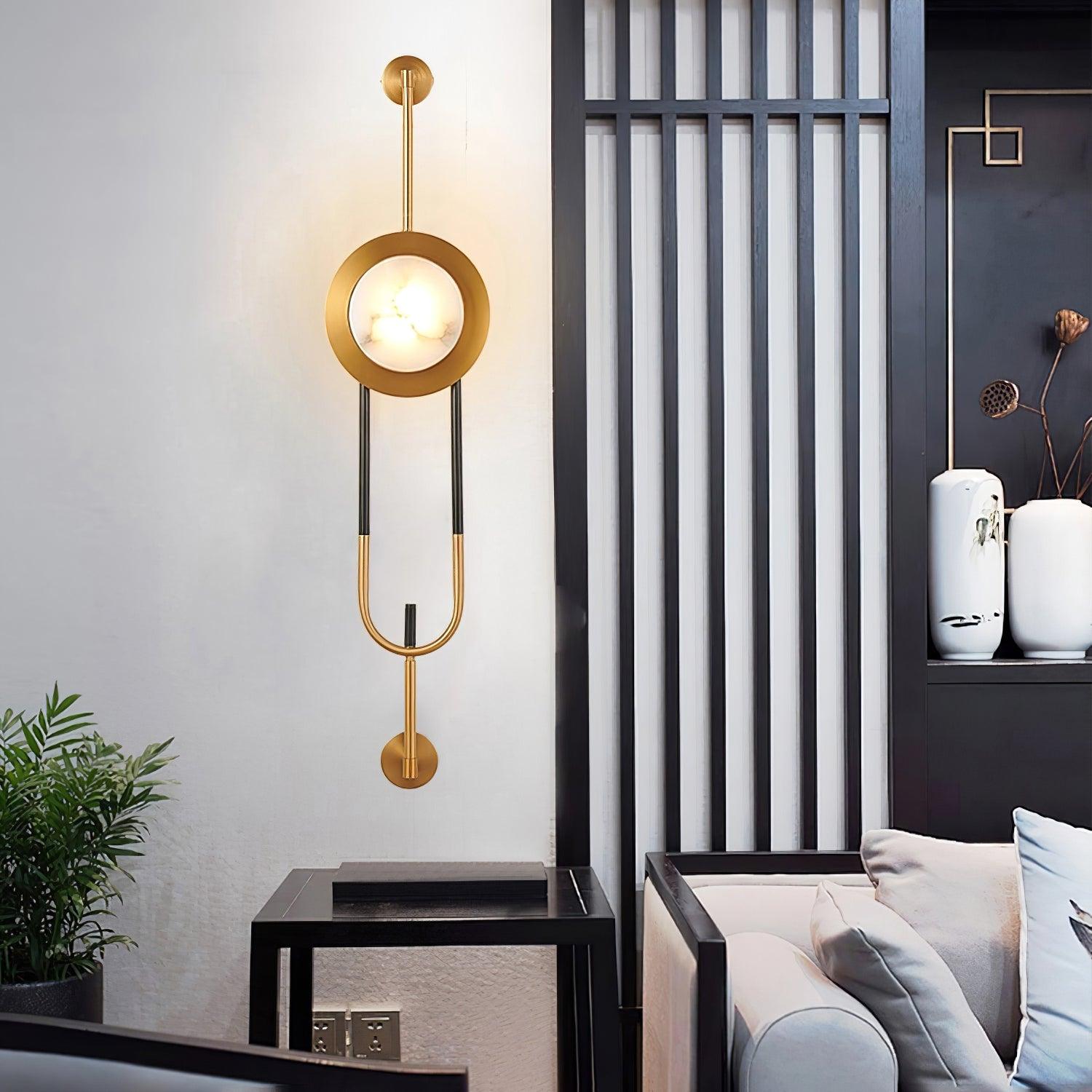 Lit marble wall light beside a black slatted divider, vases and a light-colored sofa