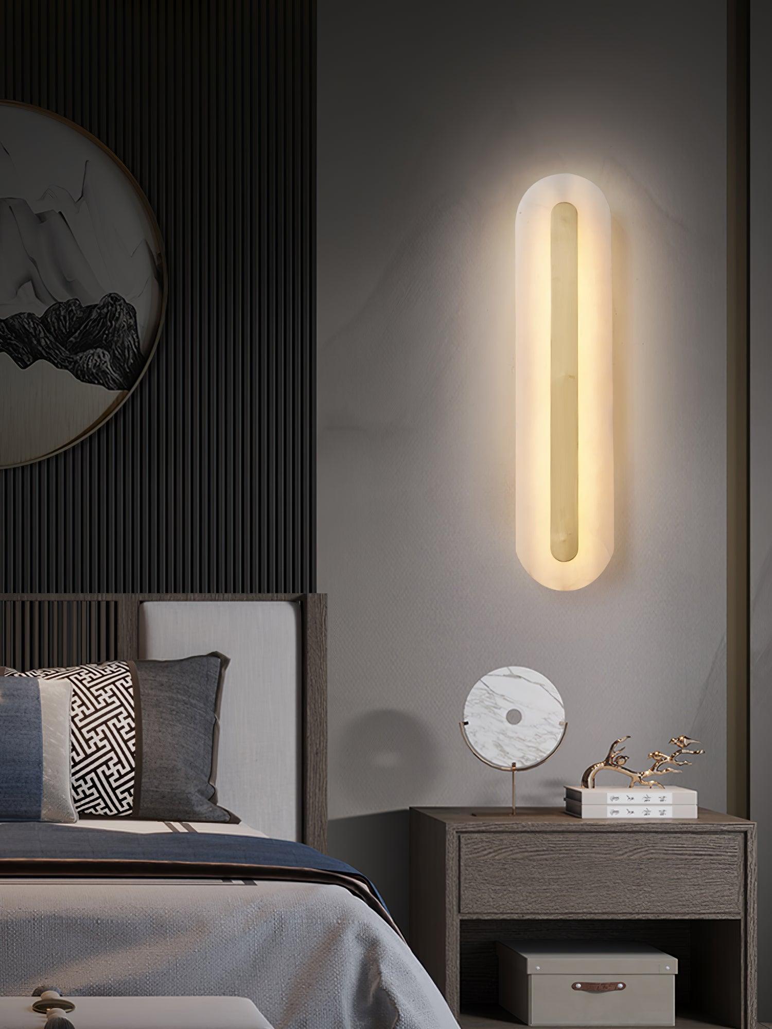Rounded wall light above a small bedside cabinet