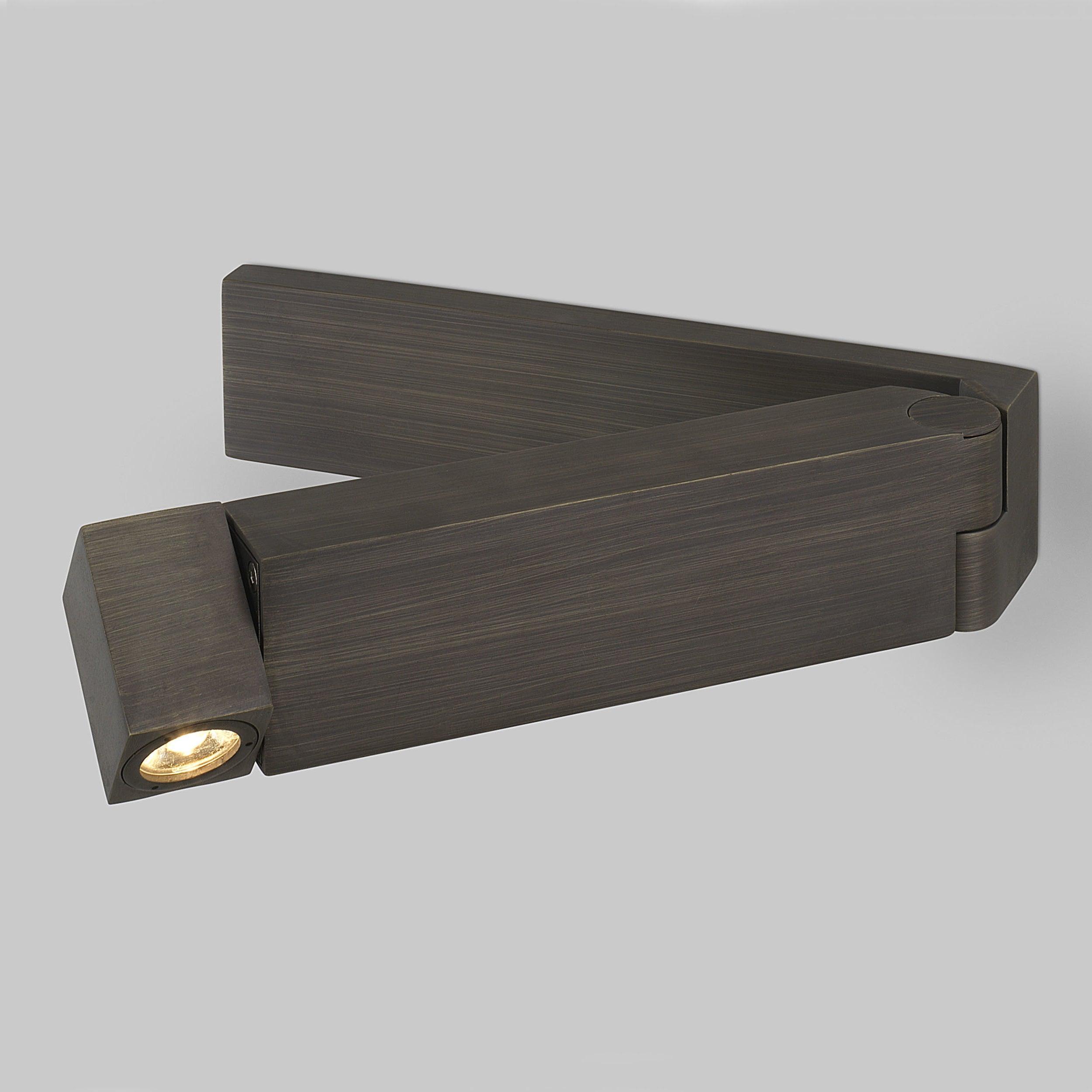 Close dark fine-grained rectangular backplate and opened arm, right hinge and lit head at left on grey background