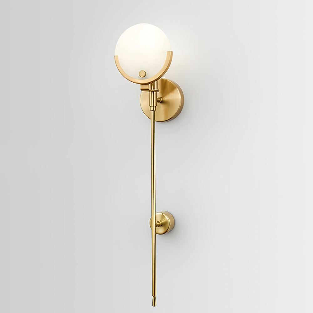 Closer view of a lit round white shade, brass lower half-rim and long stem with a lower round wall support
