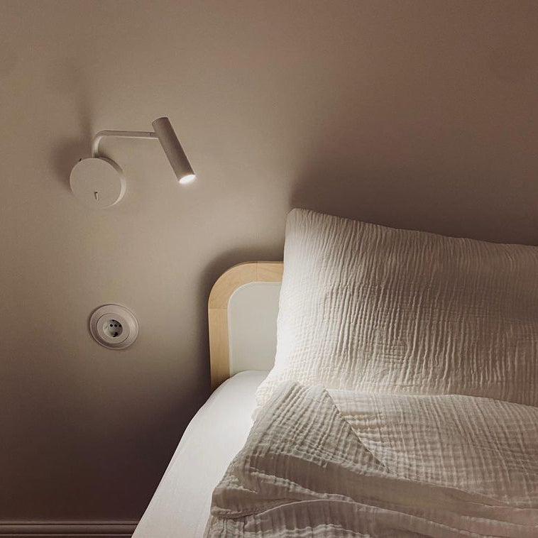 White articulated light above a bedside area