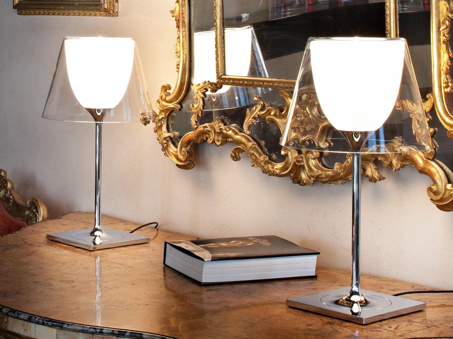 Two Chrome Prism lamps on a console below framed mirrors
