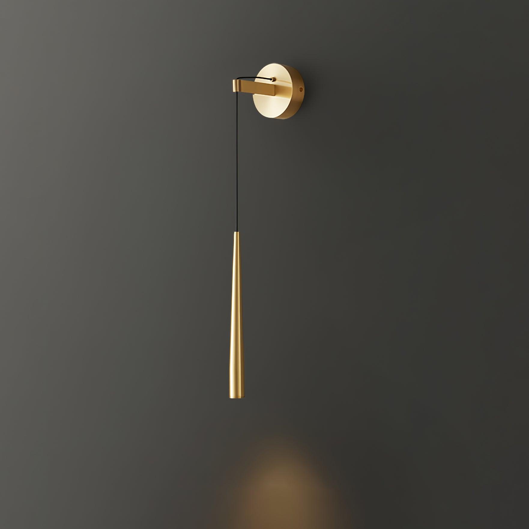 Plain-ended brass-tone tapered wall light lit against dark grey with a downward glow