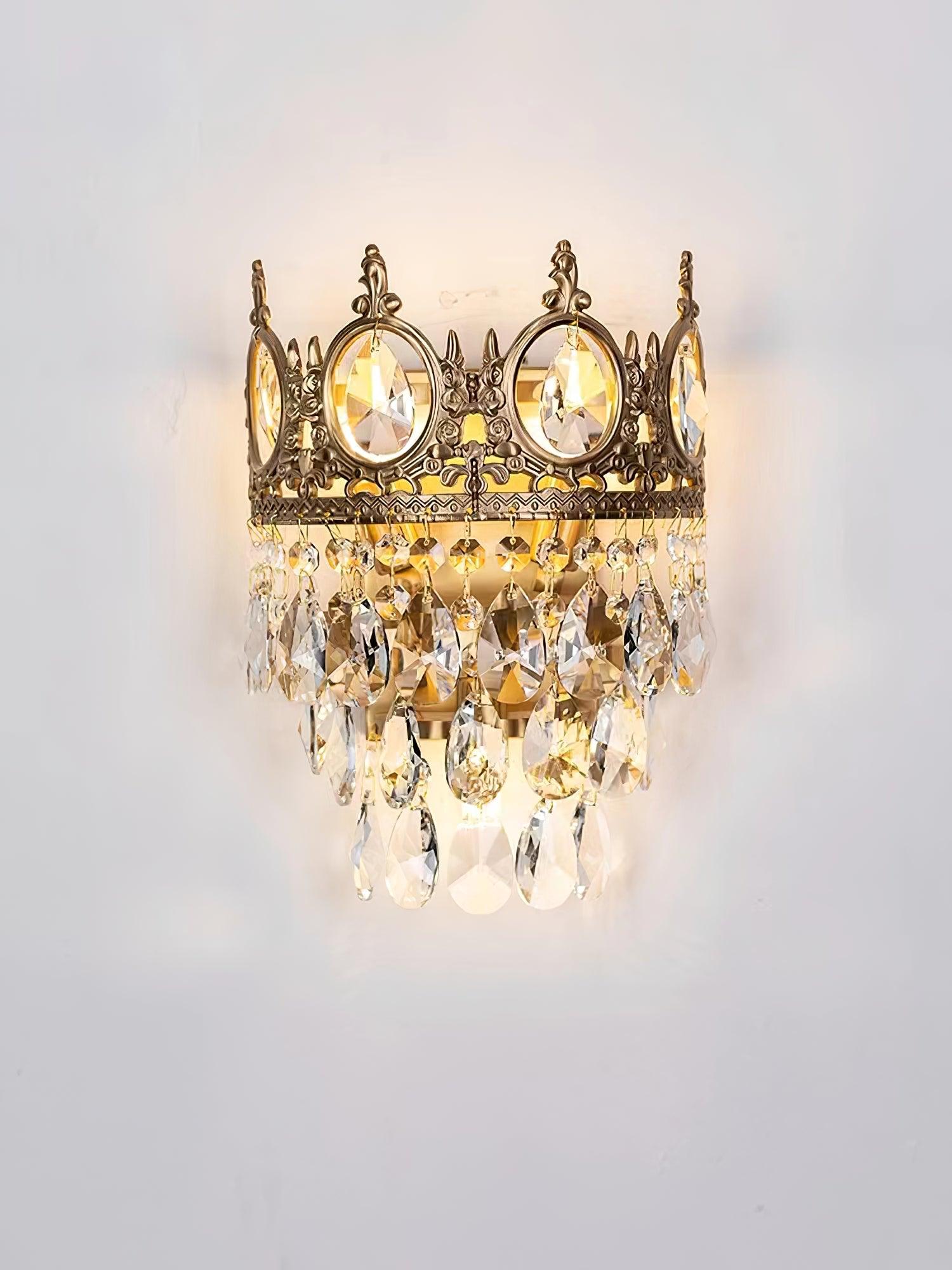Tiered crystal sconce glowing on a white wall