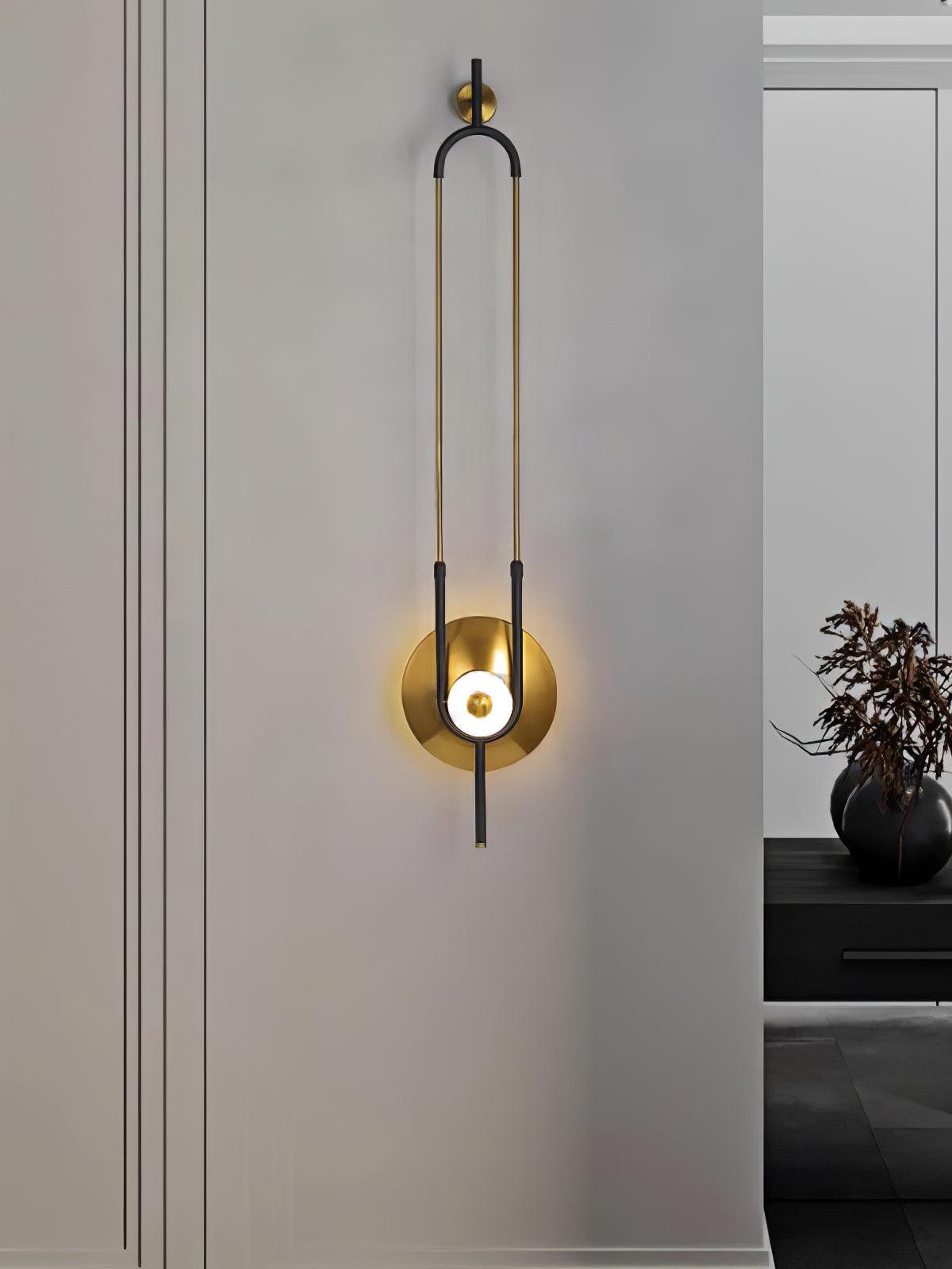 Tall wall light on pale panel beside dark console and black flower vase, with baseboard below