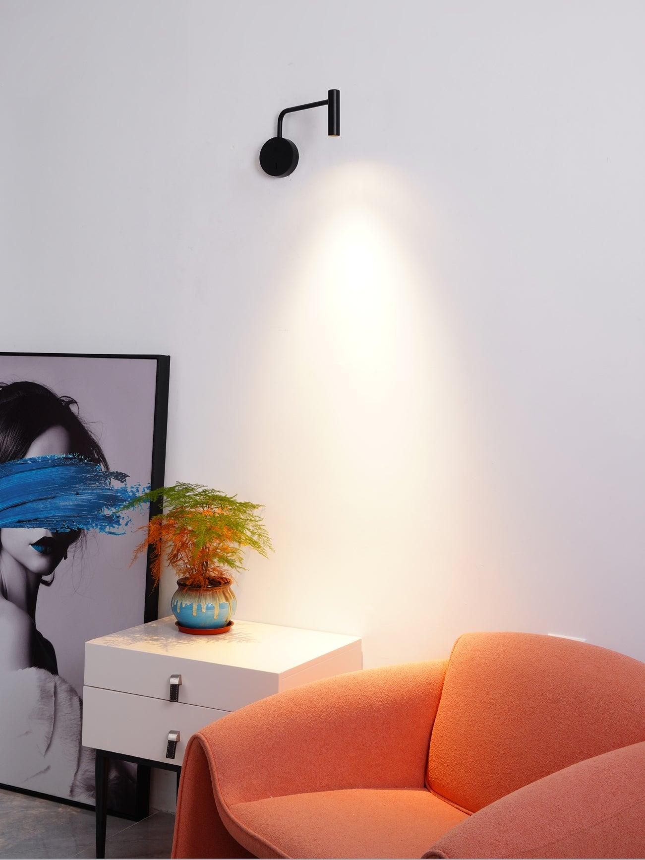 Black L-arm light beside an orange chair