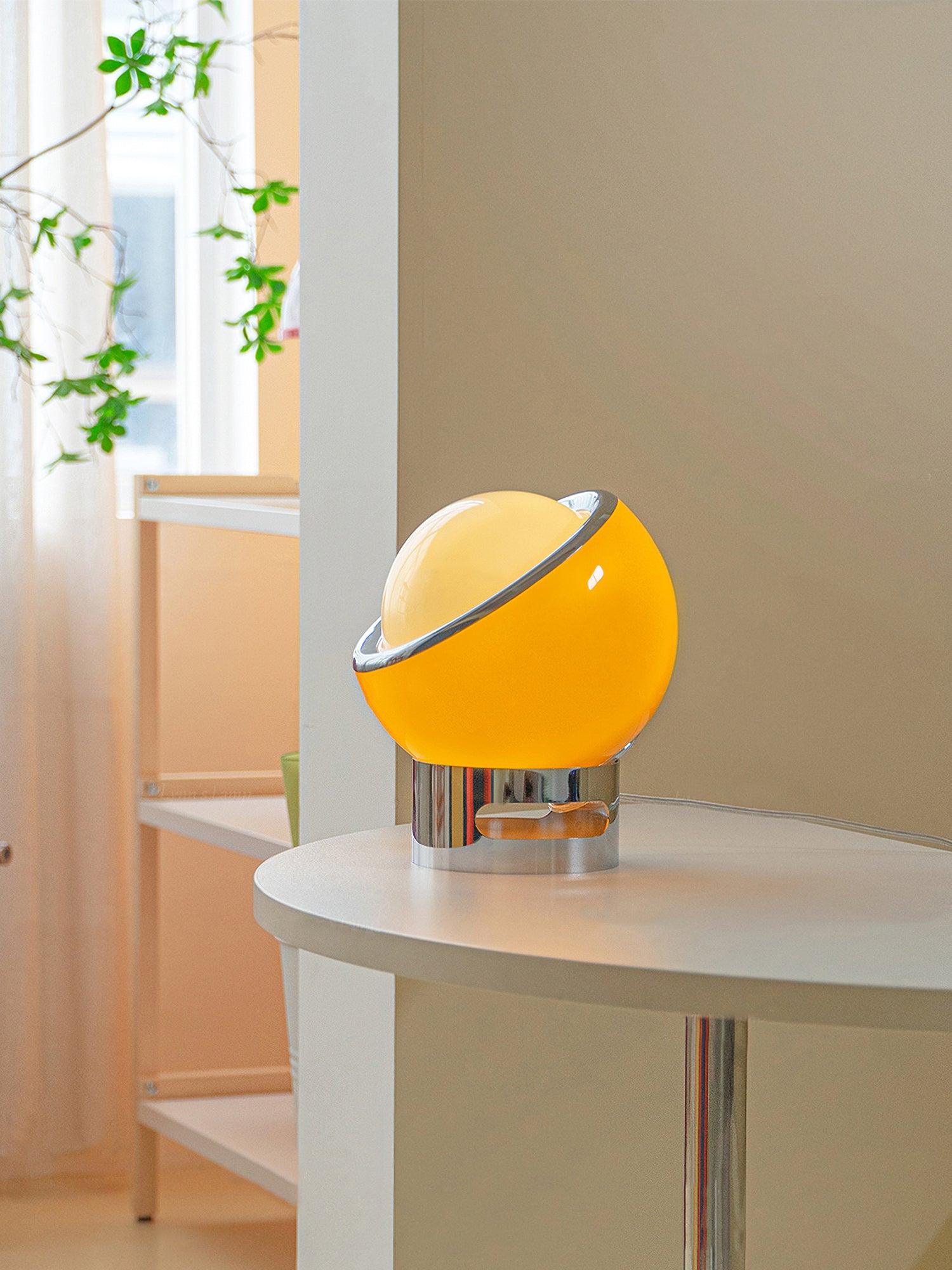Valeria lamp on a round side table beside a window