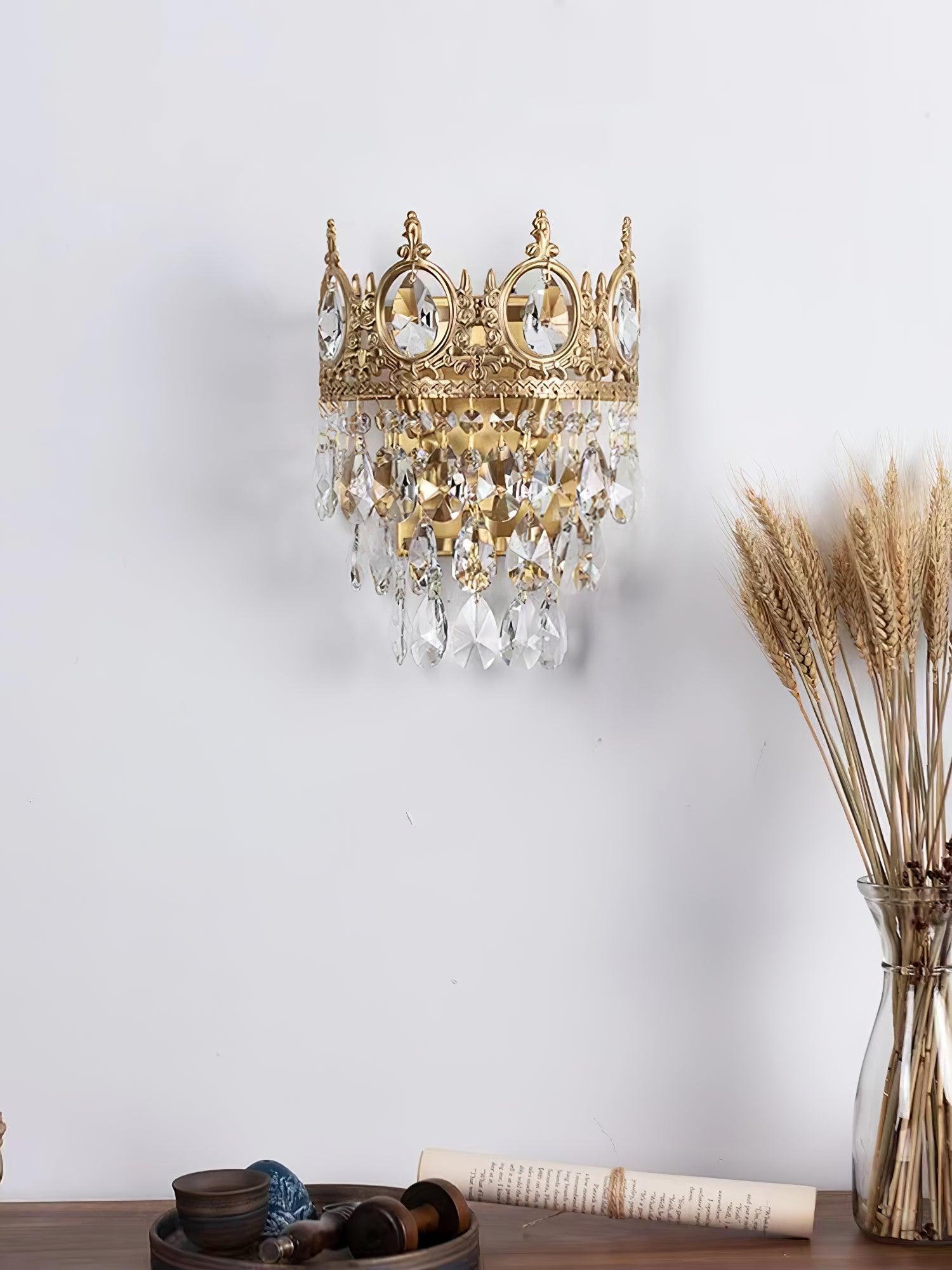 Crown-style wall light beside a vase of dried stems
