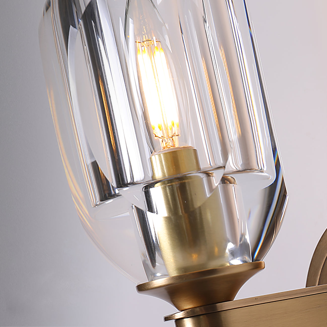 Close-up of faceted shade around a lit filament-style bulb