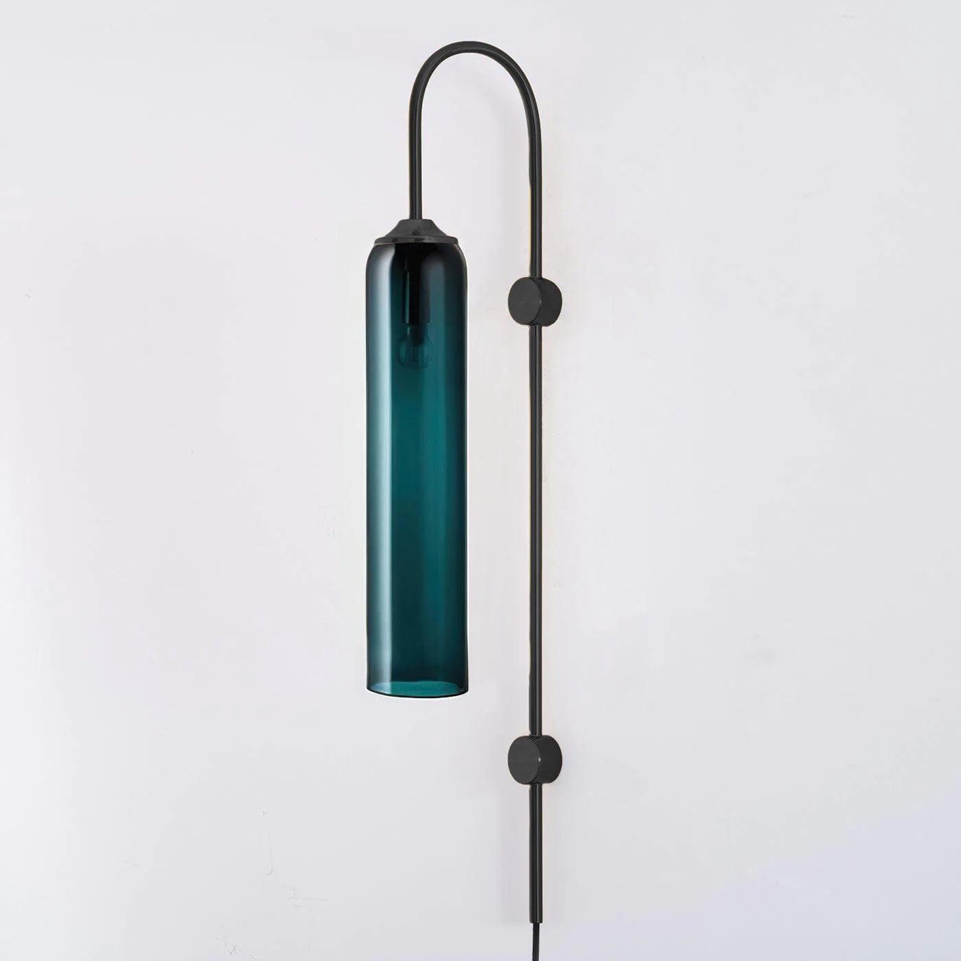Deep teal glass tube on a black curved wall frame