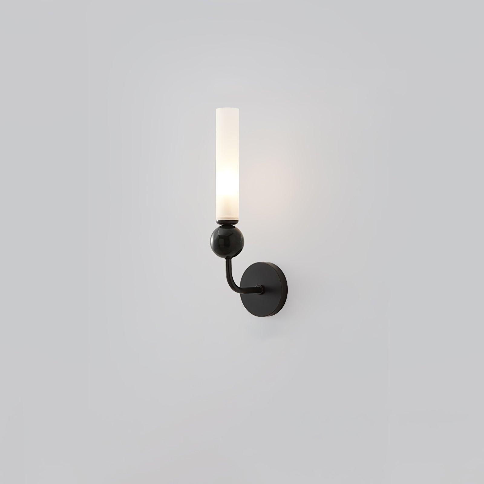Curved-arm black wall lamp with round black plate, glossy dark marble sphere and lit upright white cylindrical diffuser