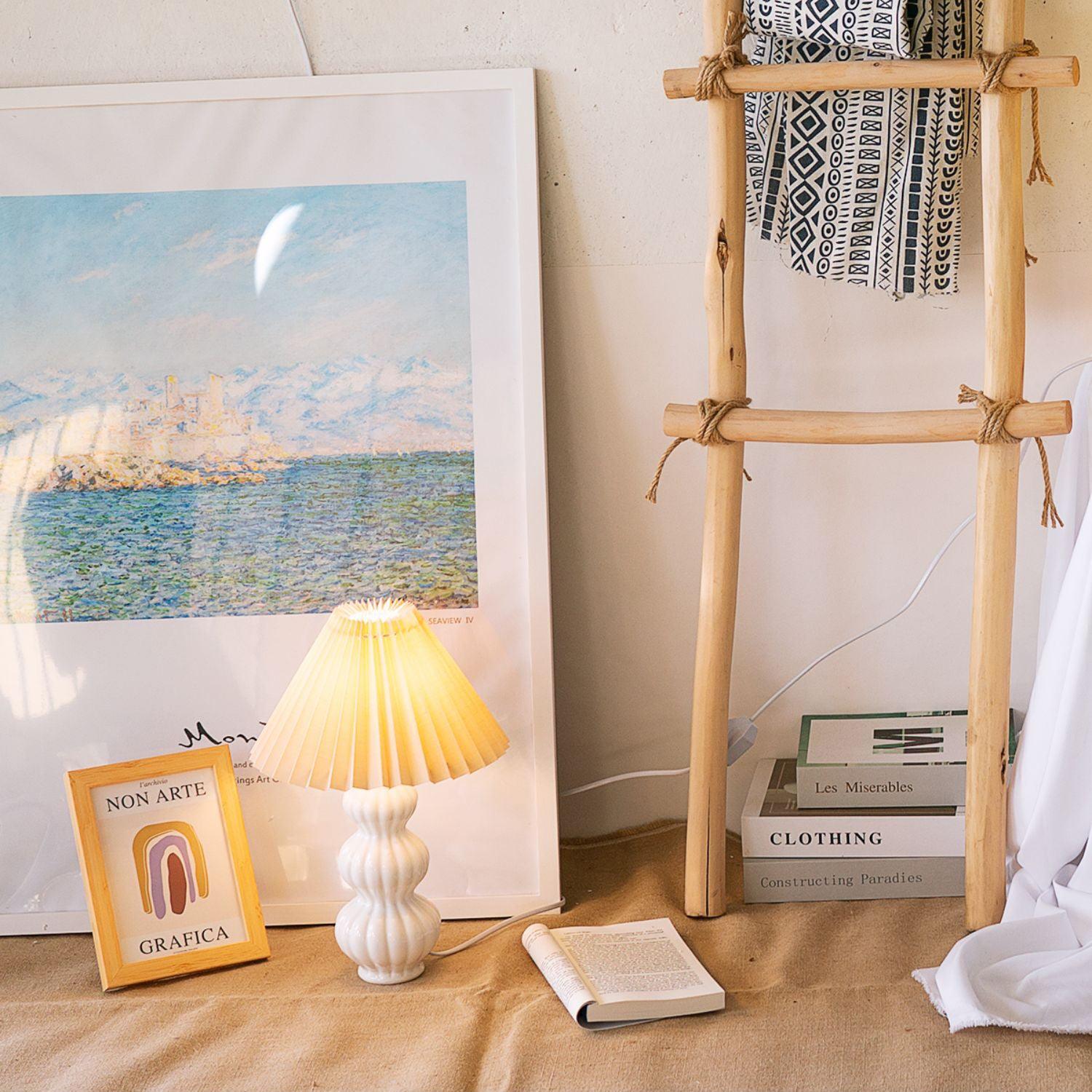 Leo table lamp beside books and framed art