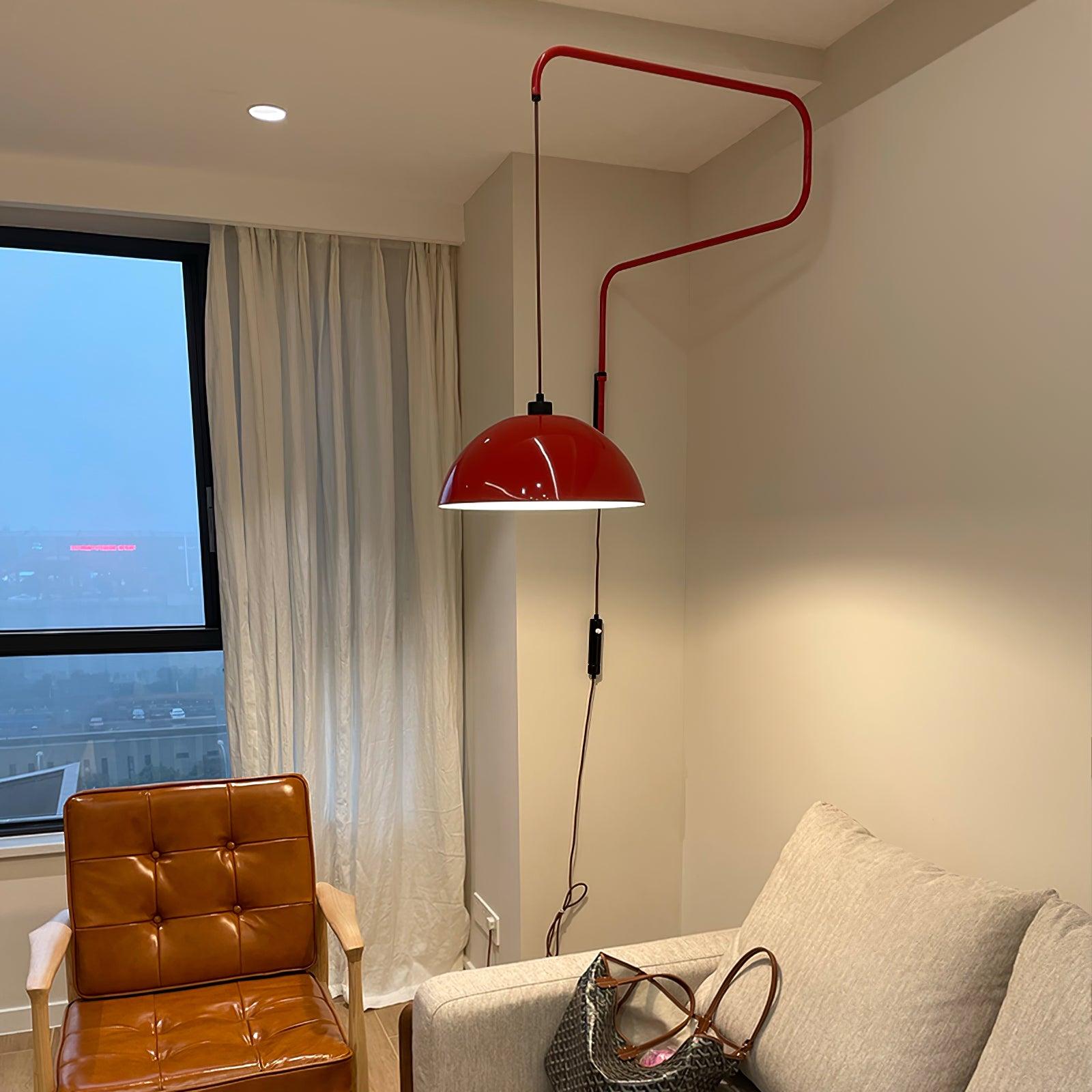 Red dome wall light beside a sofa near a window