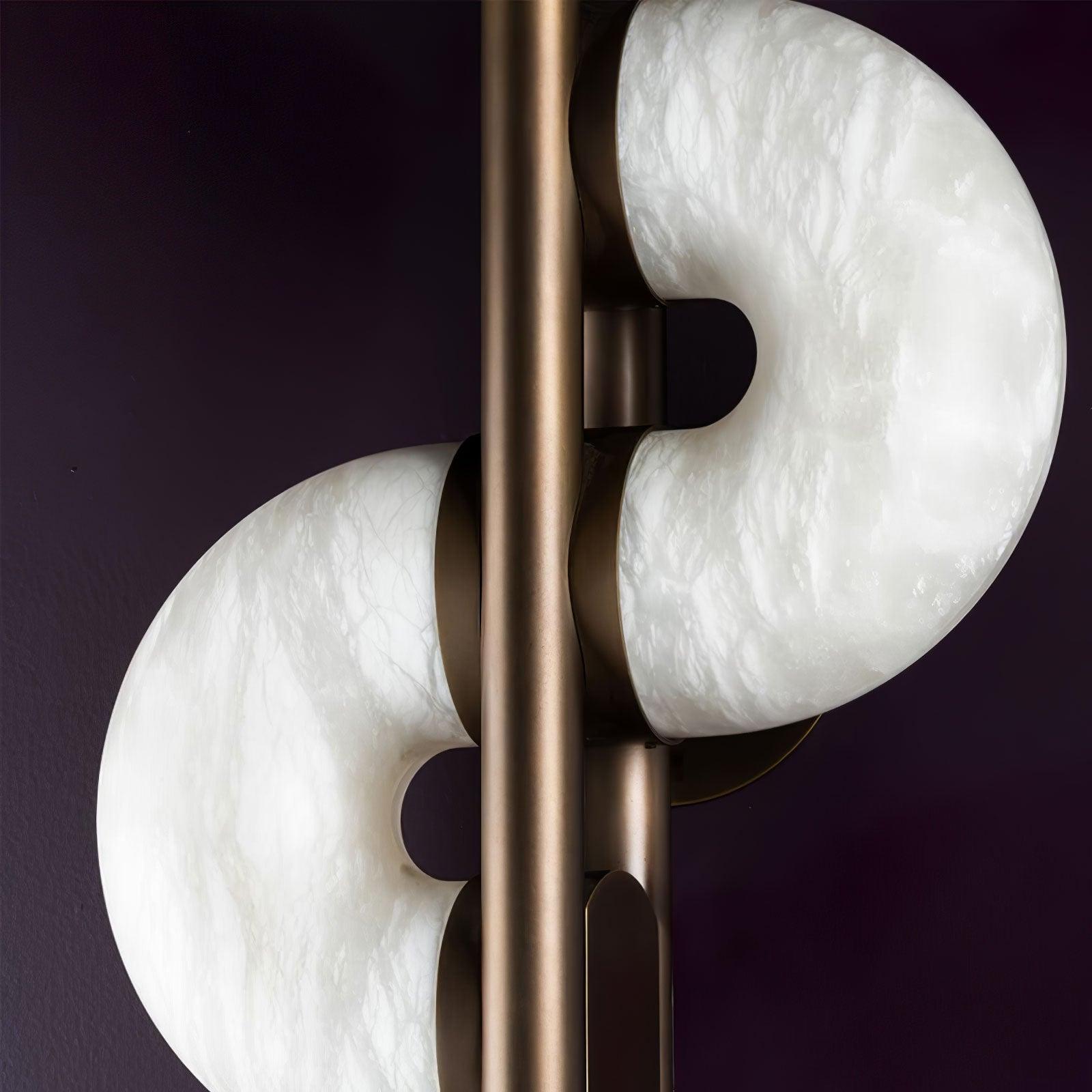 Unlit close-up of white and grey stone veining, rounded notches, bronze tube and rounded rear attachment caps