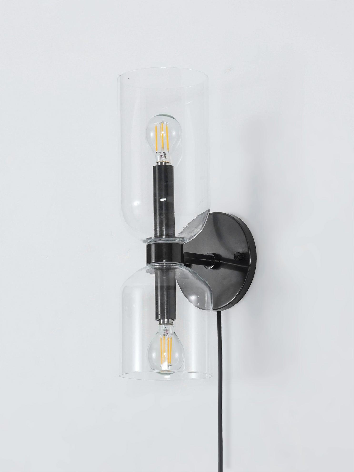 Side view of clear glass cylinders, black wall plate and hanging cord