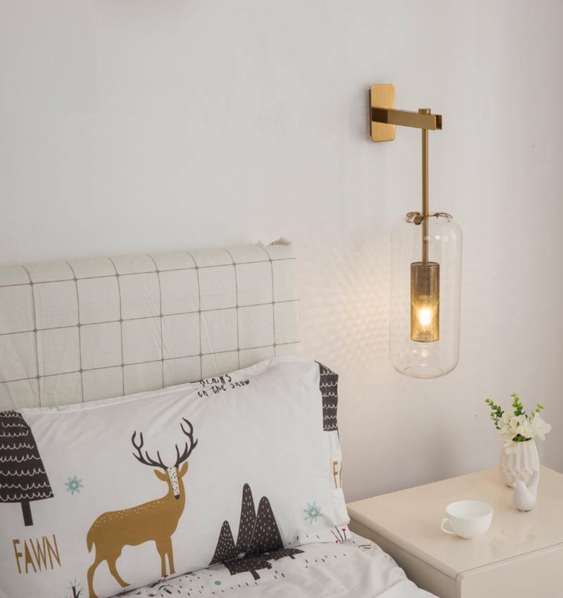 Glass wall sconce beside a bed