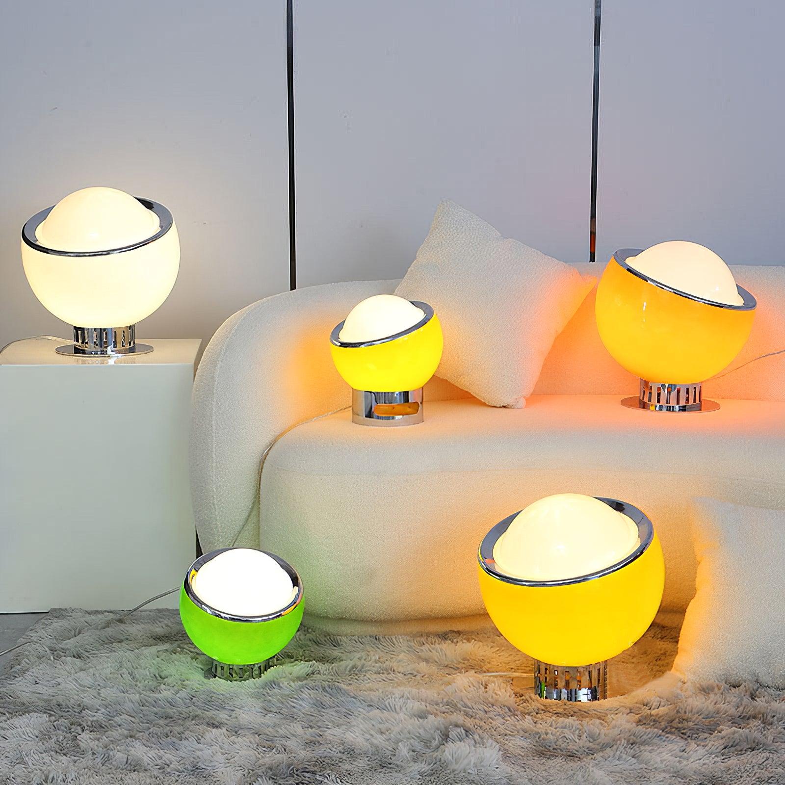 Several Valeria lamps in different colours and sizes beside a sofa