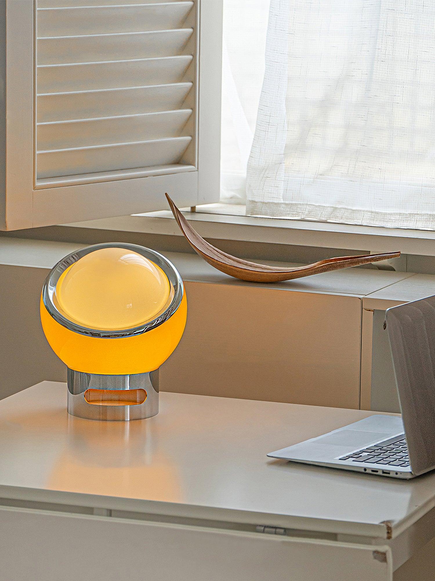 Valeria lamp on a desk beside a laptop and shuttered window