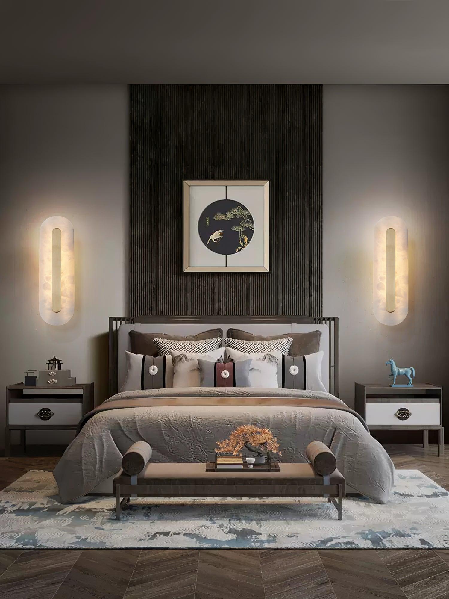 Two vertical alabaster lights beside a bed