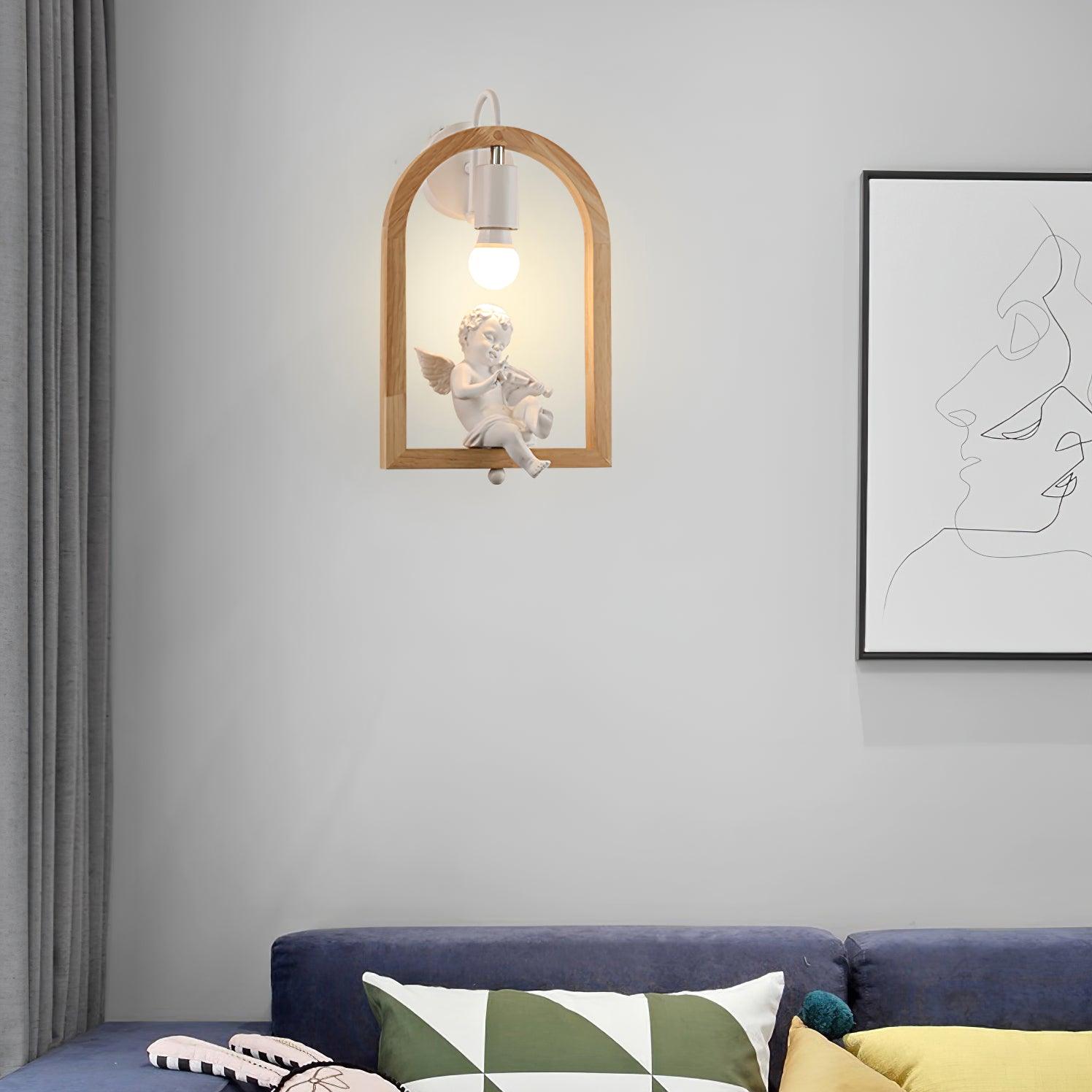Cherub wall light above a blue sofa and patterned cushions, beside a grey curtain and framed line drawing