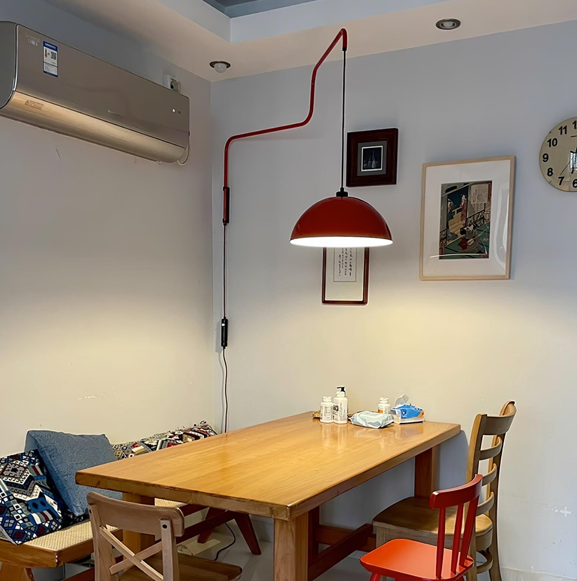 Red wall-mounted shade over a wooden dining table