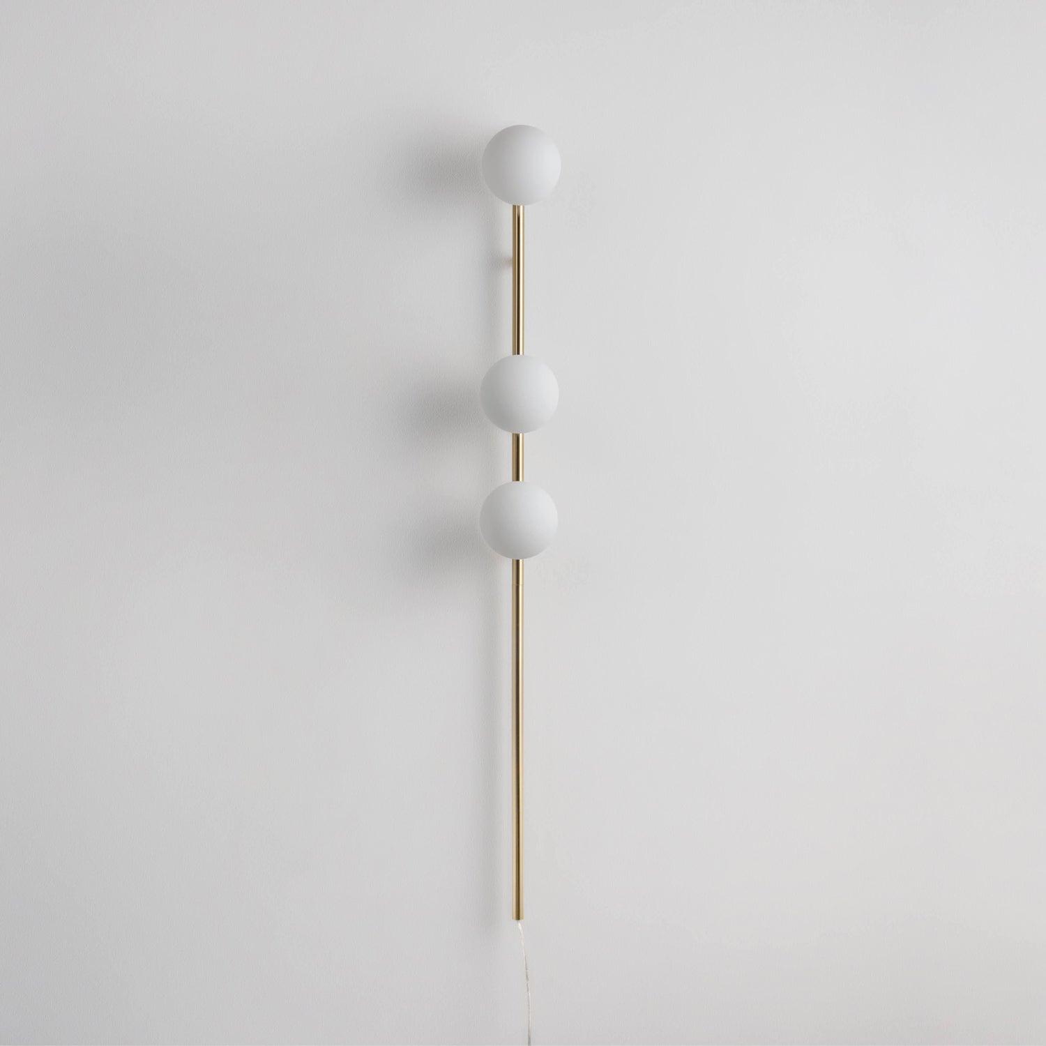 Gold option image, three unlit white glass globes along slender gold-tone rod with long lower stem and pale cord