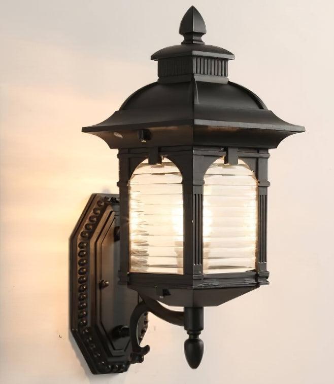 Black Miller wall lantern illuminated against a pale wall